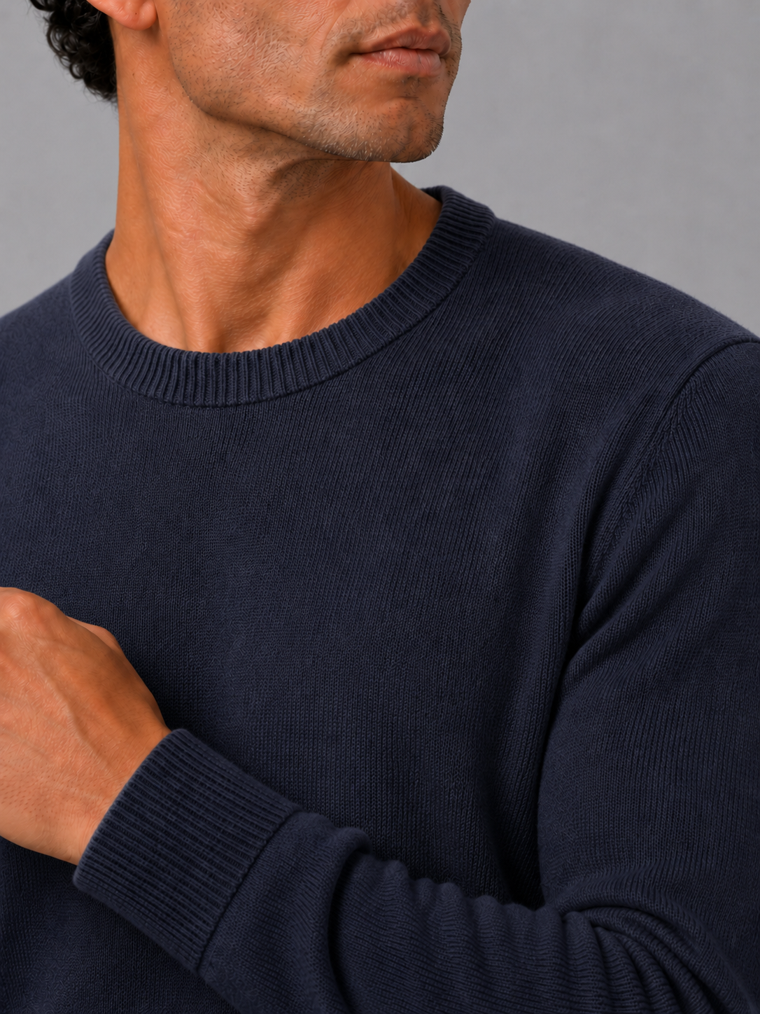 Close up of navy knit sweater showing soft lightweight fabric and clean crew neck detail
