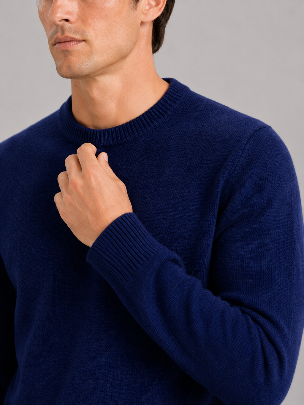 Close up of navy knit sweater showing soft textured fabric and classic crew neck detail