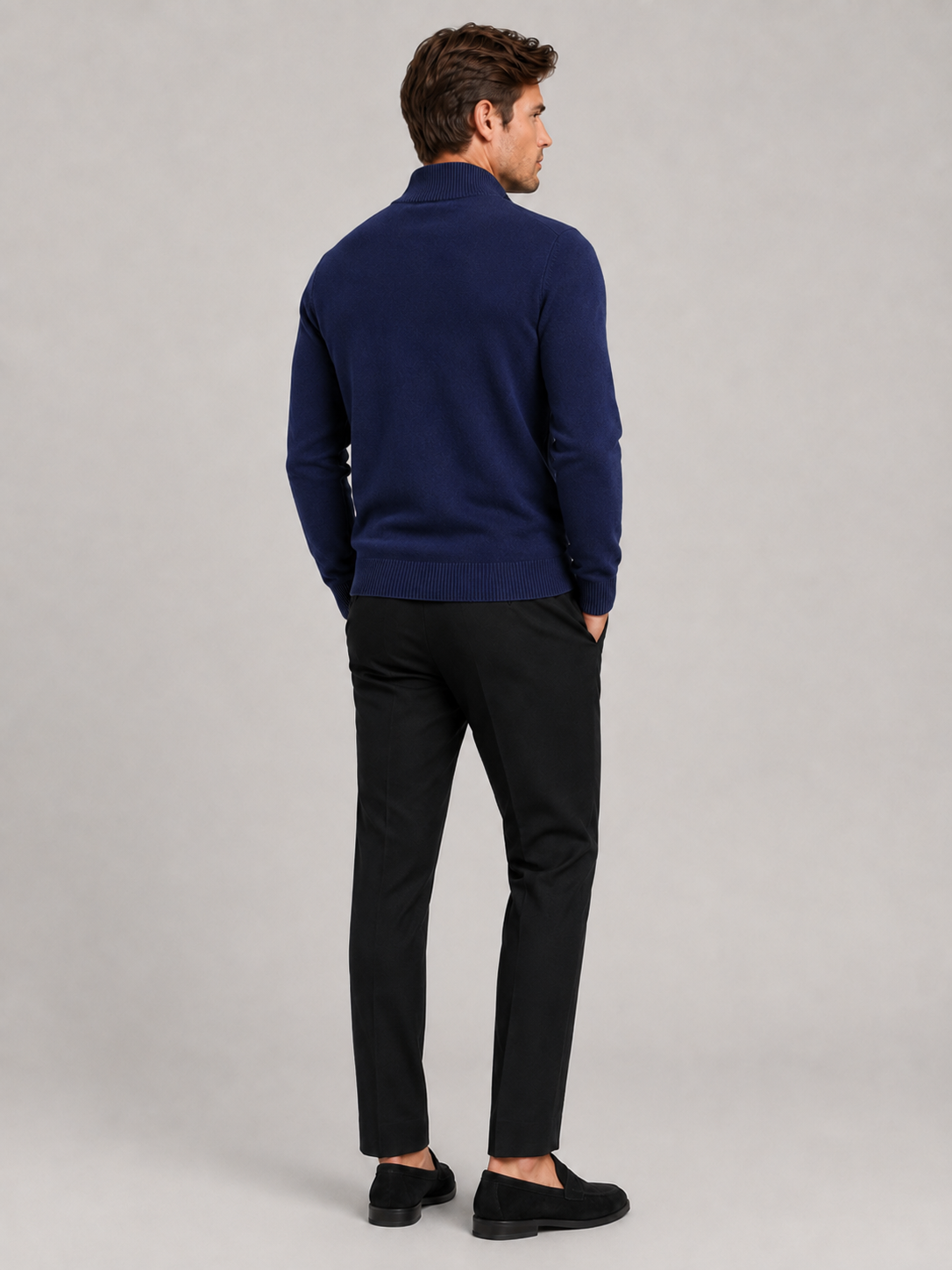 Back view of a man wearing a navy full zip knit sweater showing the slim fit, long sleeves, and clean knit construction
