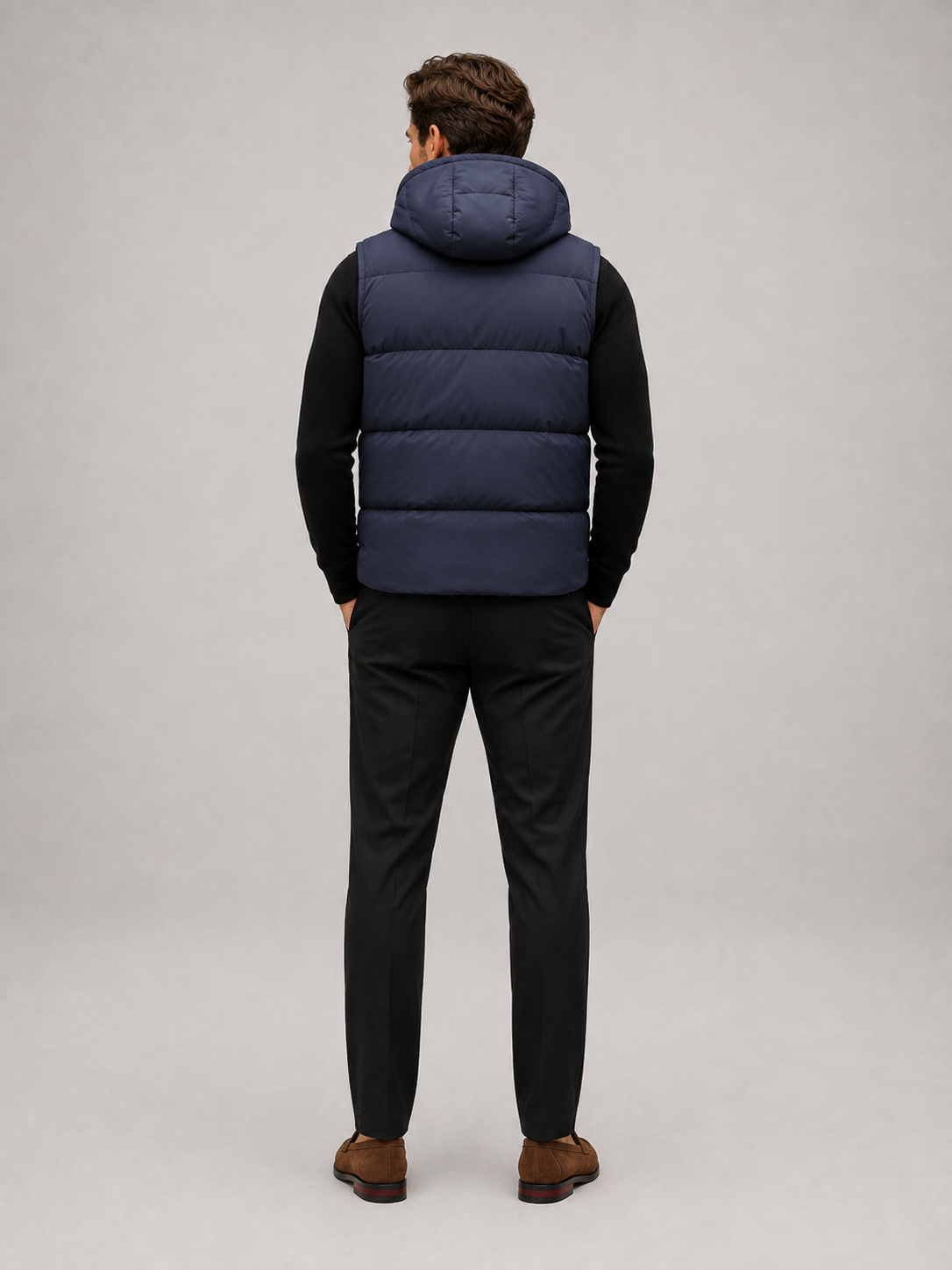 Man wearing a black hooded puffer vest in a casual fall winter outfit for outdoor and everyday wear