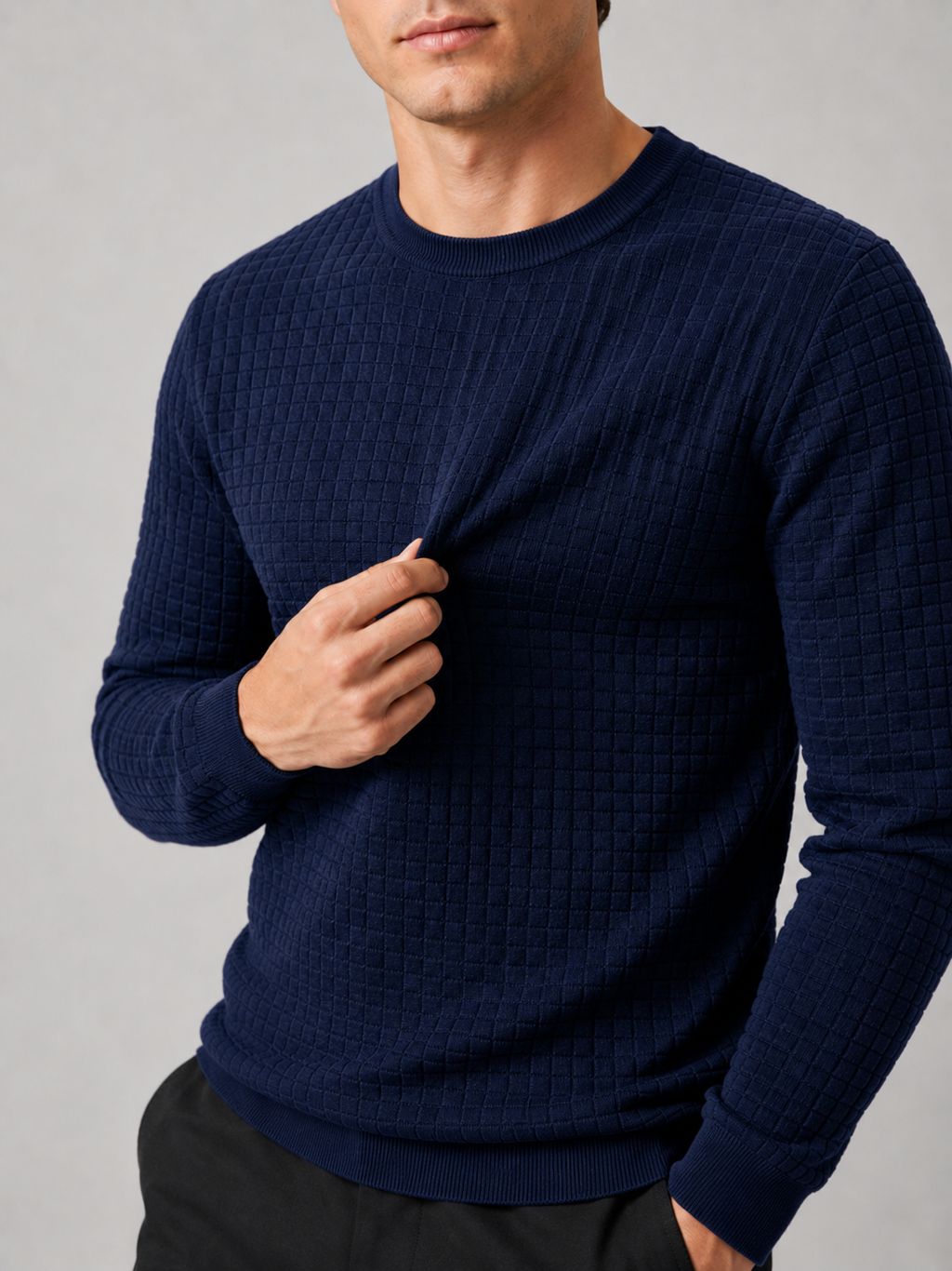 Close up of navy jacquard sweater showing textured knit pattern and classic crew neck detail