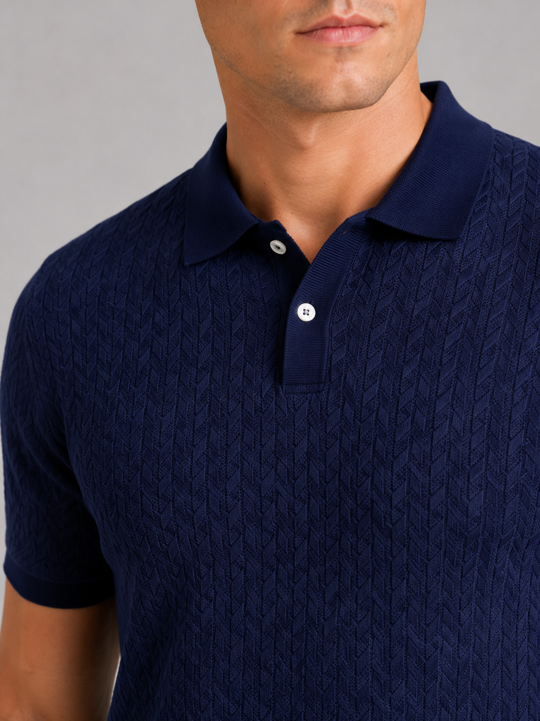 Close up of navy knit polo shirt showing soft breathable fabric and refined collar detail