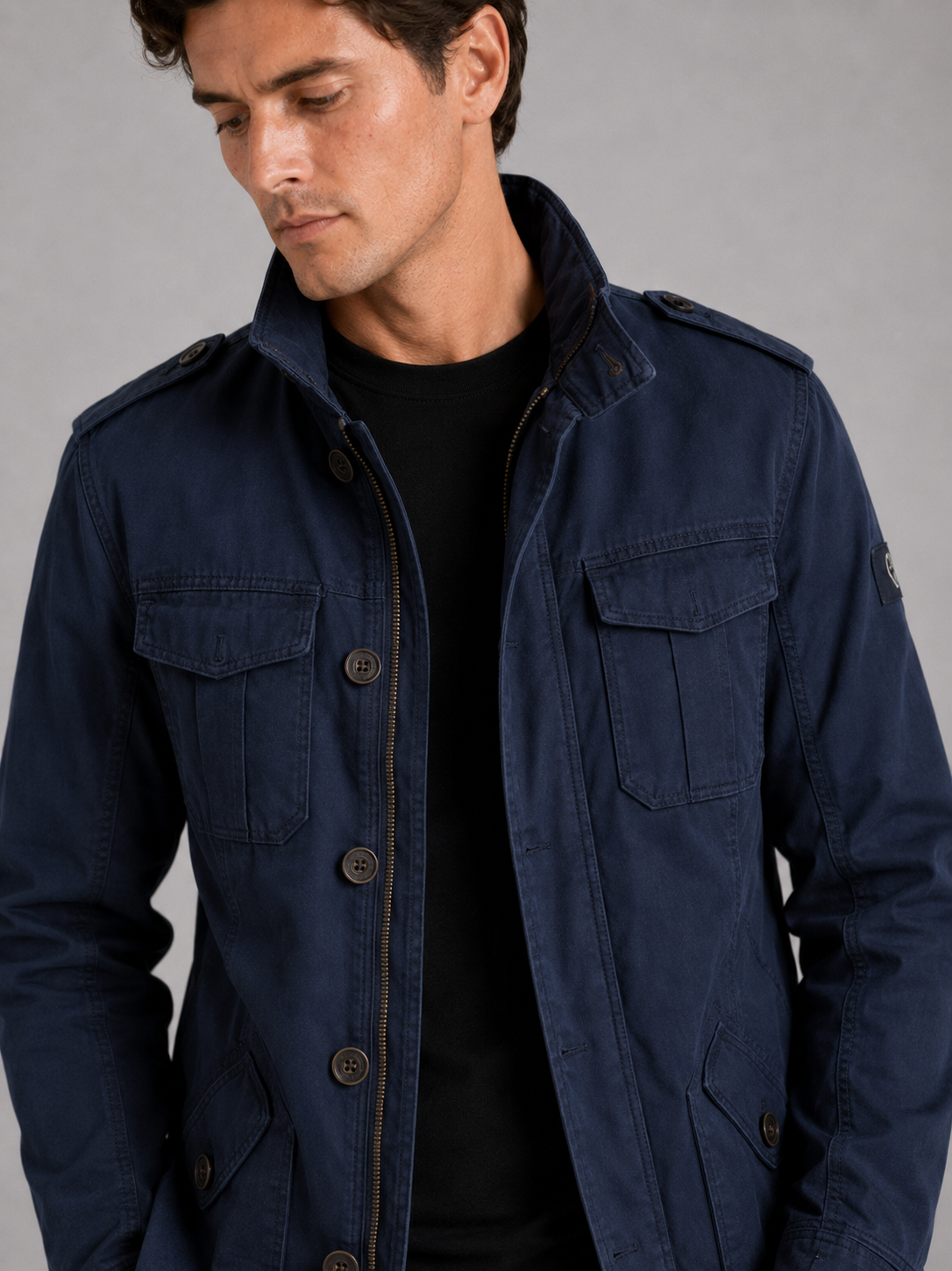 Close up of navy military cargo jacket showing durable heavyweight cotton fabric and utility pocket detail