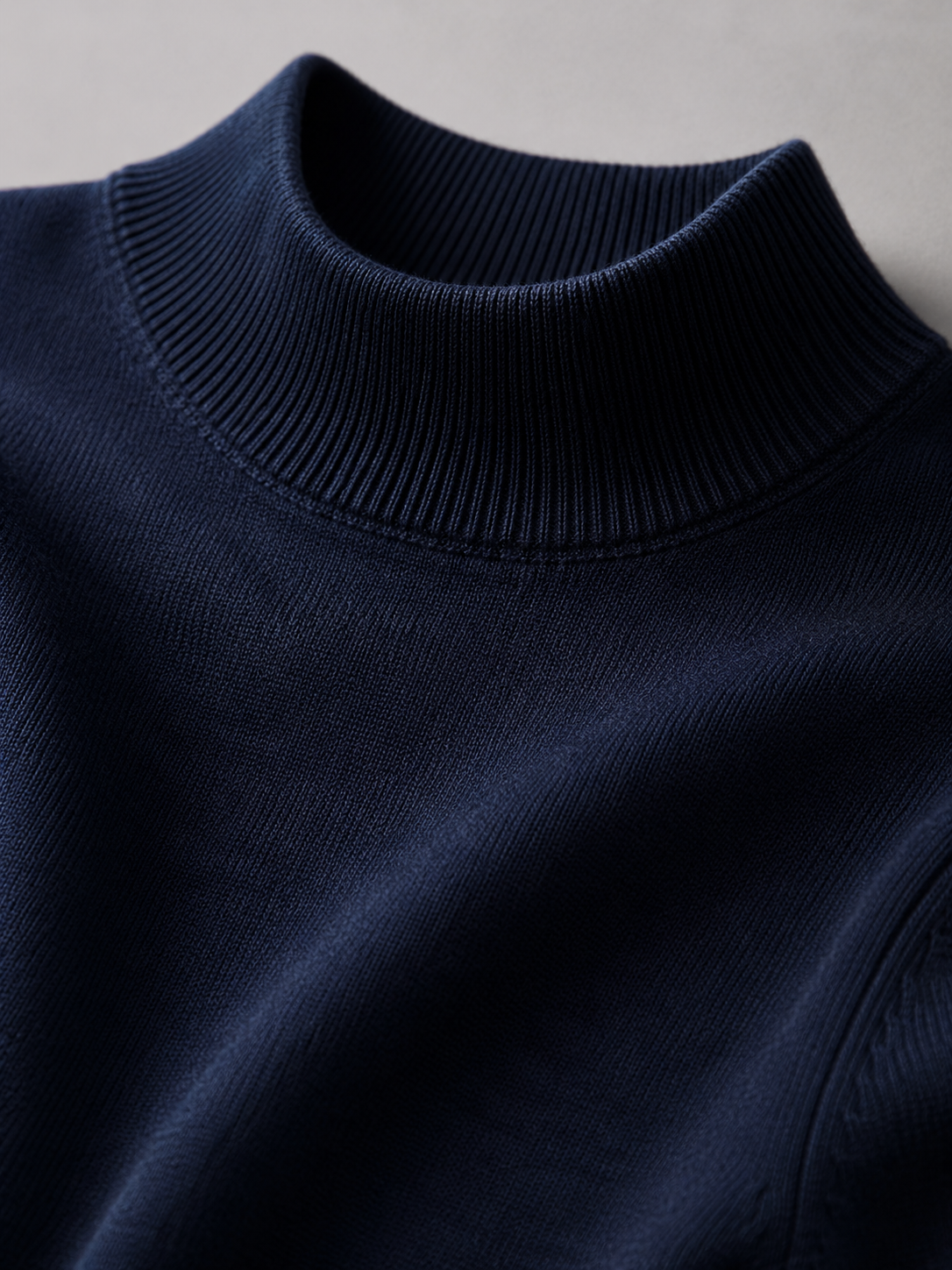 Close up of navy mock neck sweater showing soft knit texture and refined collar detail
