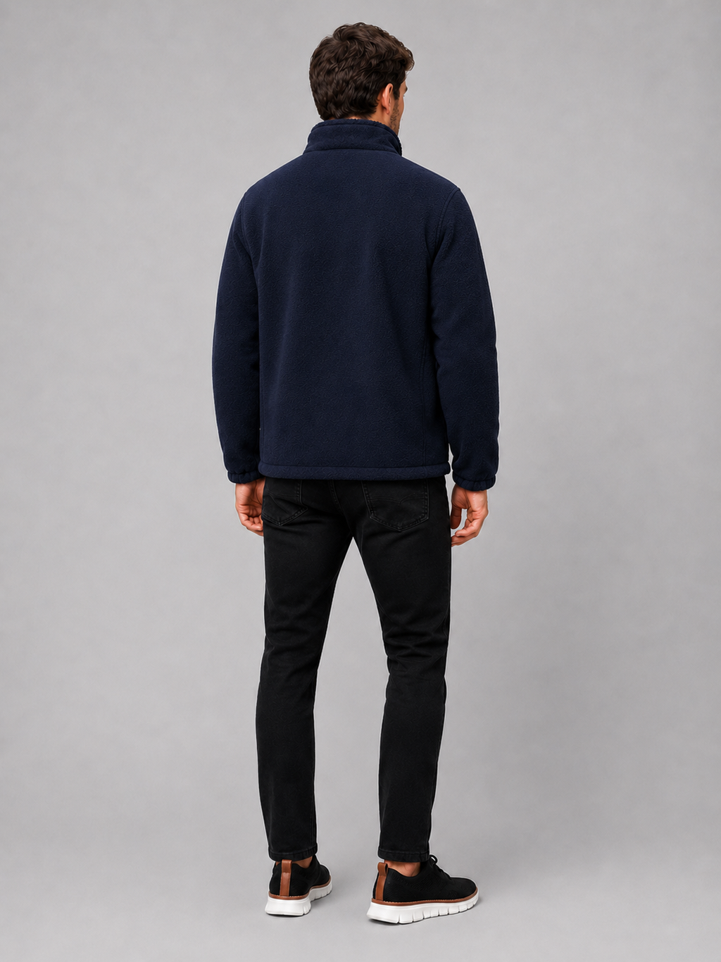 Back view of a man wearing a navy polar fleece jacket showing the stand collar, long sleeves, thick fleece construction, and comfortable outdoor fit