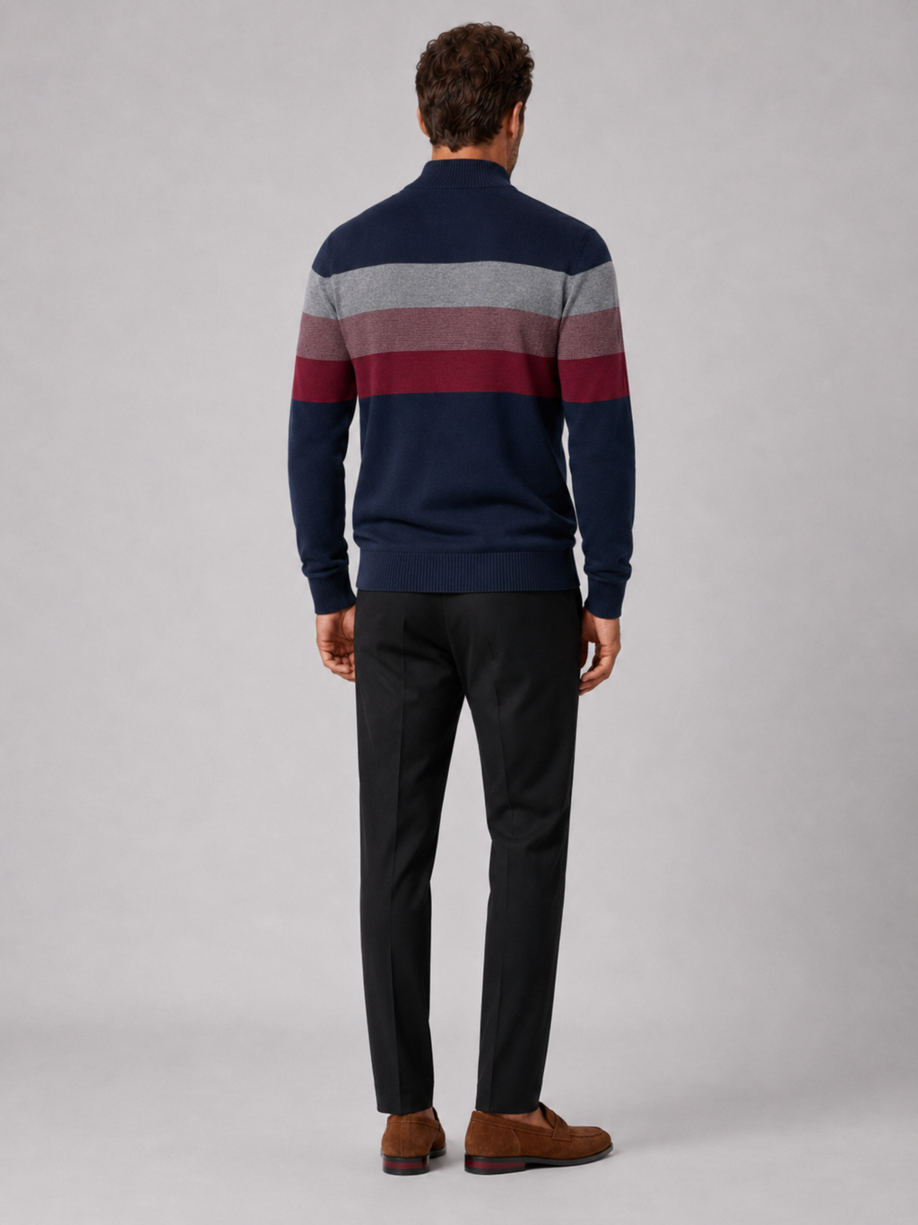 Back view of a man wearing a navy cotton quarter zip sweater showing the patchwork design and relaxed fit