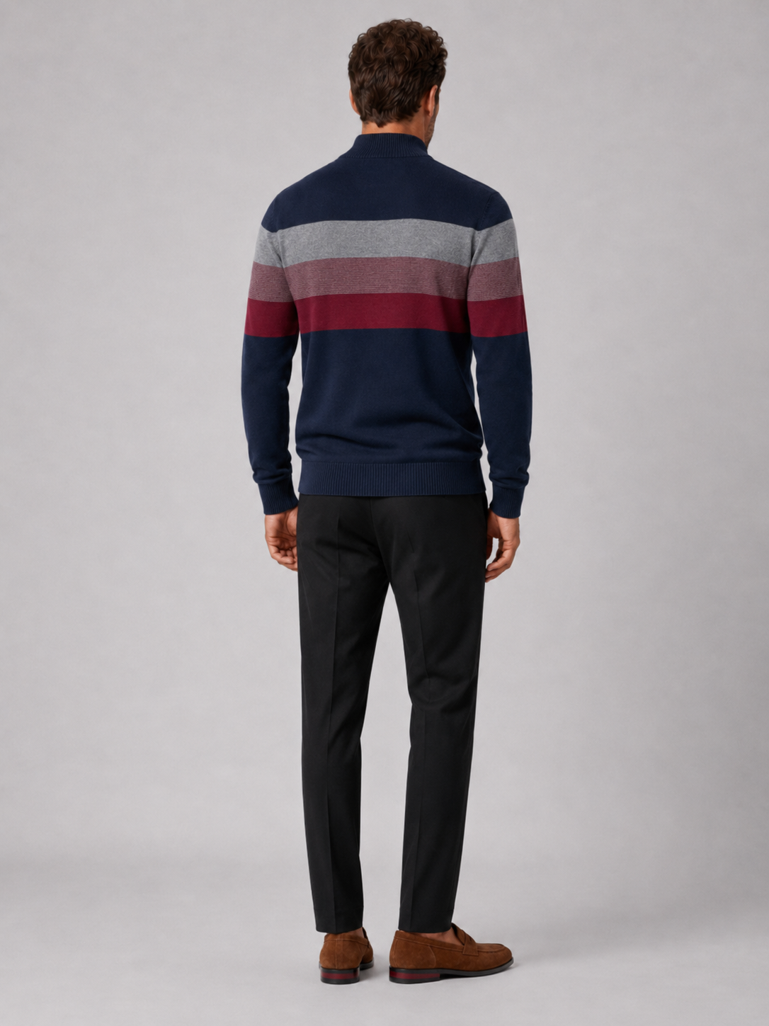 Back view of a man wearing a navy cotton quarter zip sweater showing the patchwork design and relaxed fit