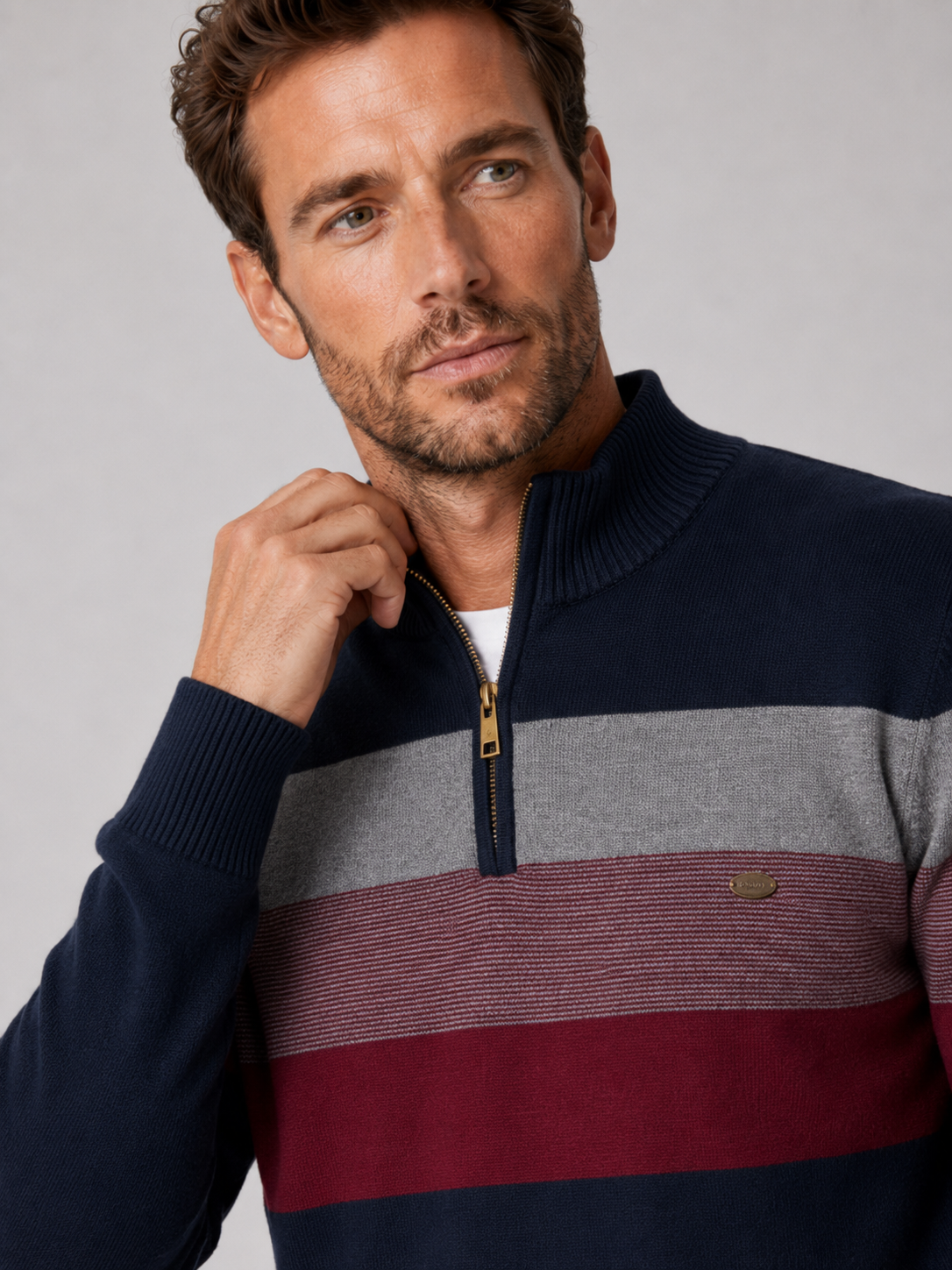 Close-up of a navy patchwork quarter zip sweater showing the cotton knit texture, mock neck, zipper, and stitching