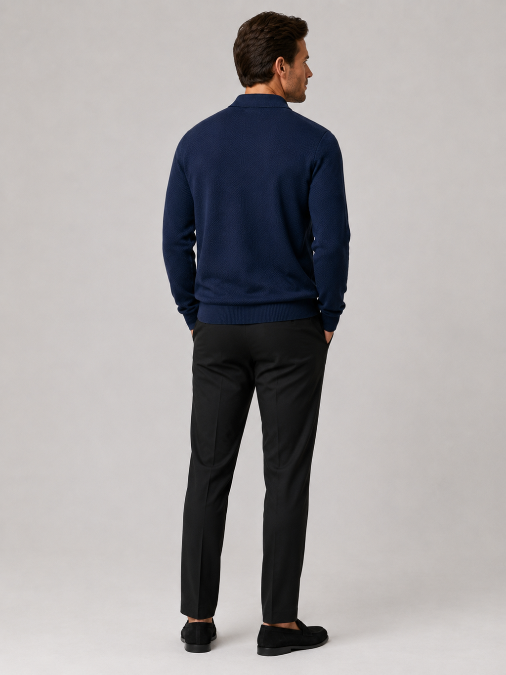 Back view of a man wearing a navy quarter zip knit polo sweater showing the lightweight fabric and regular fit