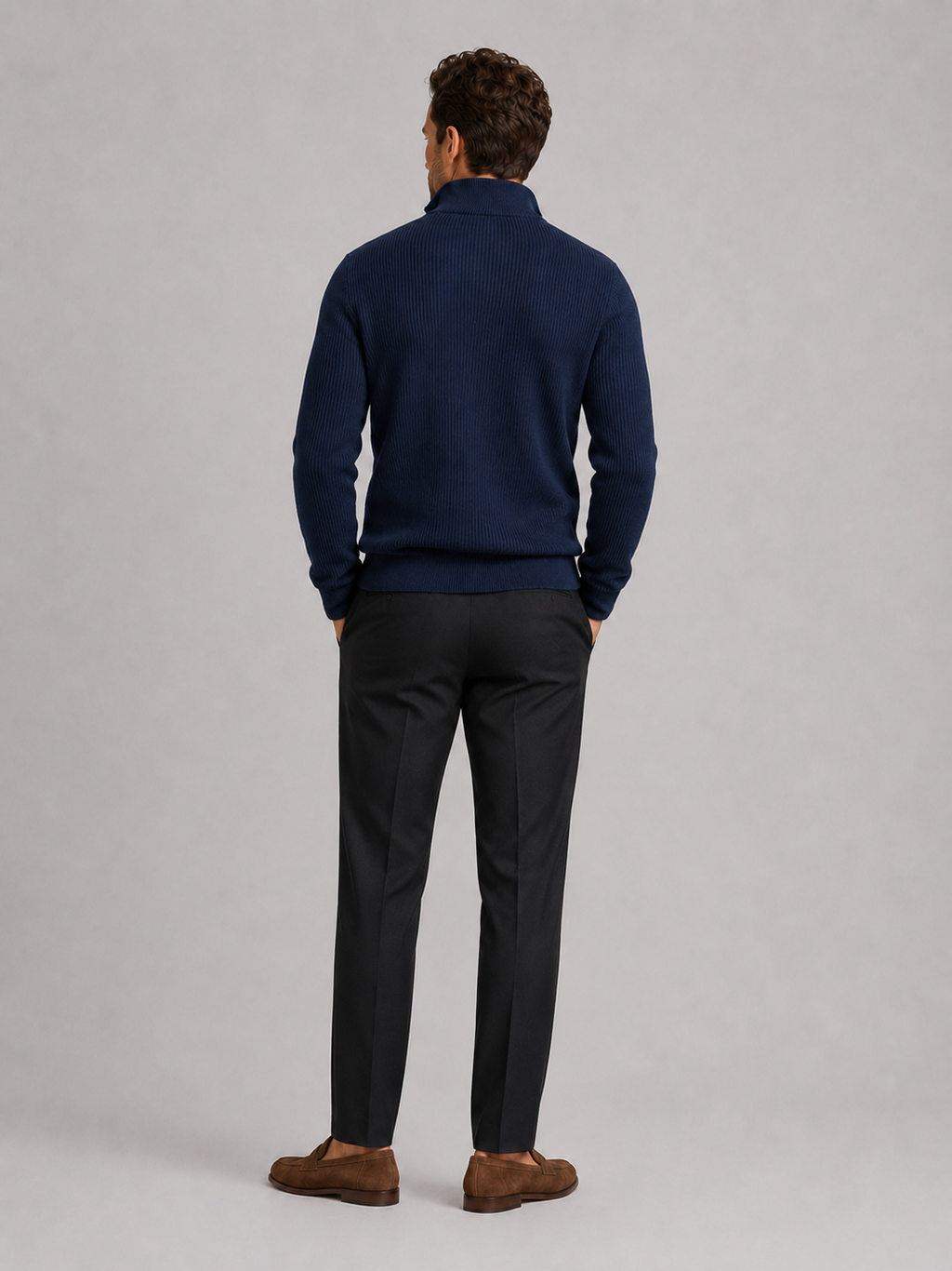 Back view of a man wearing a navy quarter zip sweater showing the slim fit, long sleeves, and clean knit finish