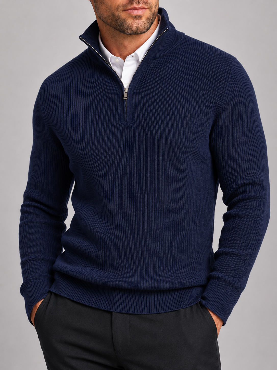 Close-up of a navy quarter zip sweater showing the warm knit texture, mock neck, zipper, cuffs, and stitching