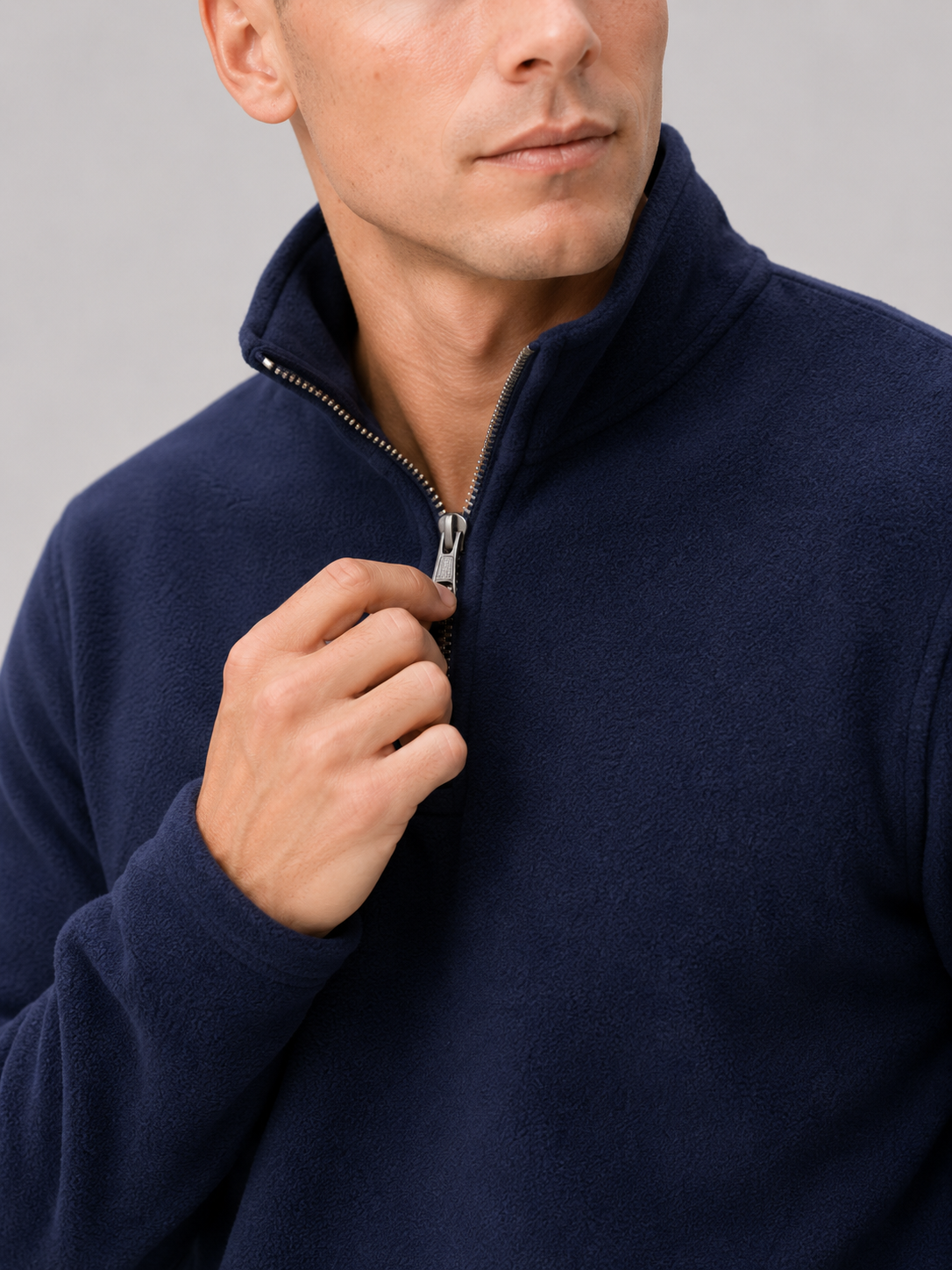 Close up of navy fleece pullover showing soft thermal fabric and quarter zip mock neck detail