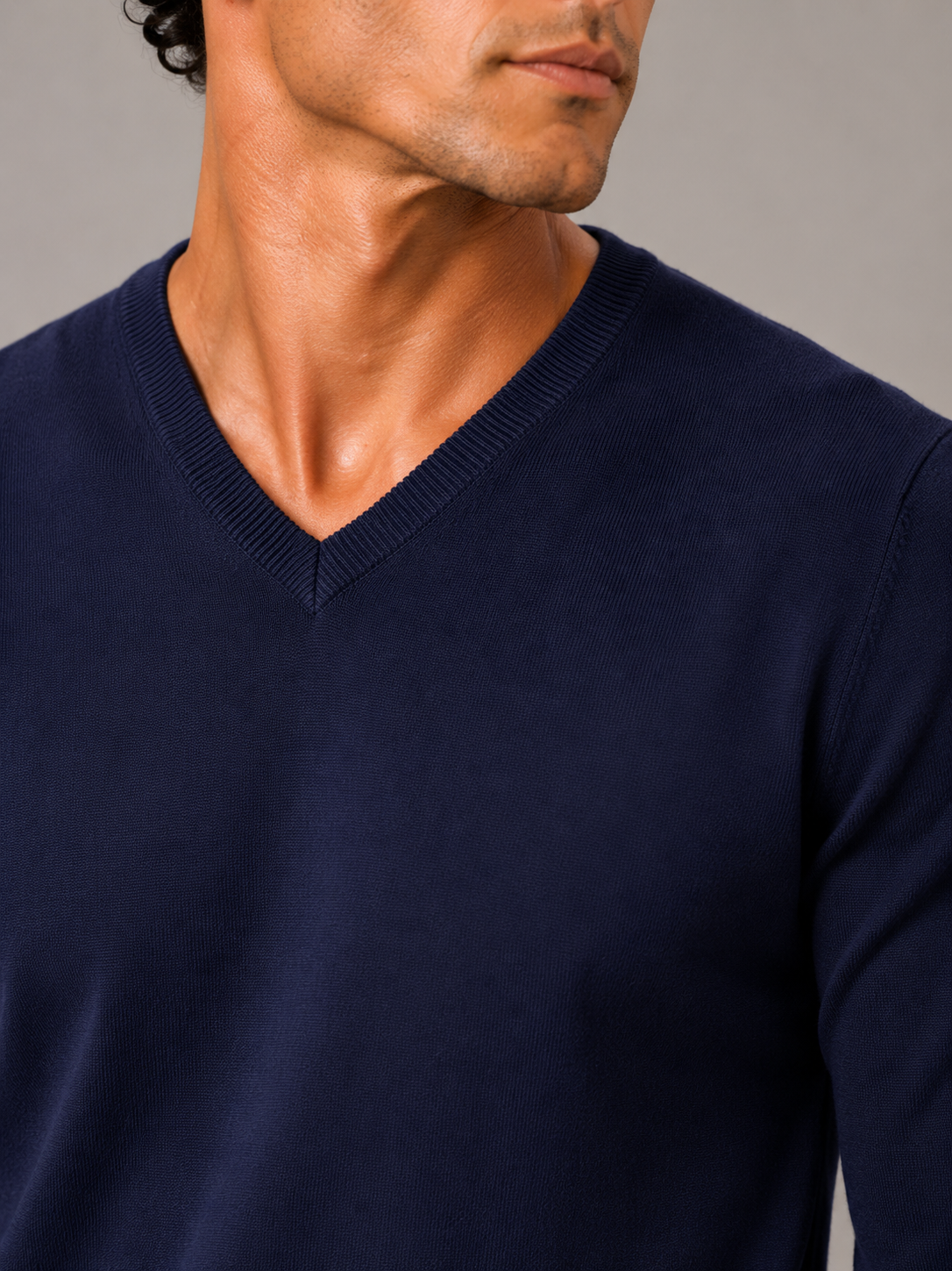 Close up of navy knit sweater showing soft lightweight fabric and refined v neck detail