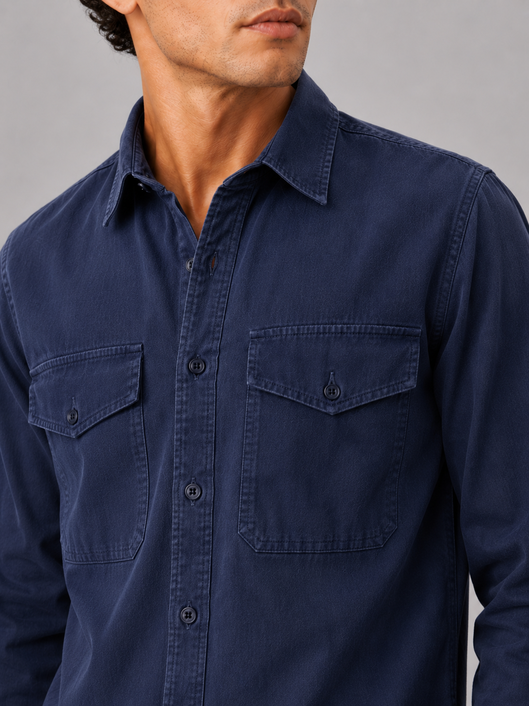 Close up of navy washed cotton work shirt showing soft fabric texture and pocket detail