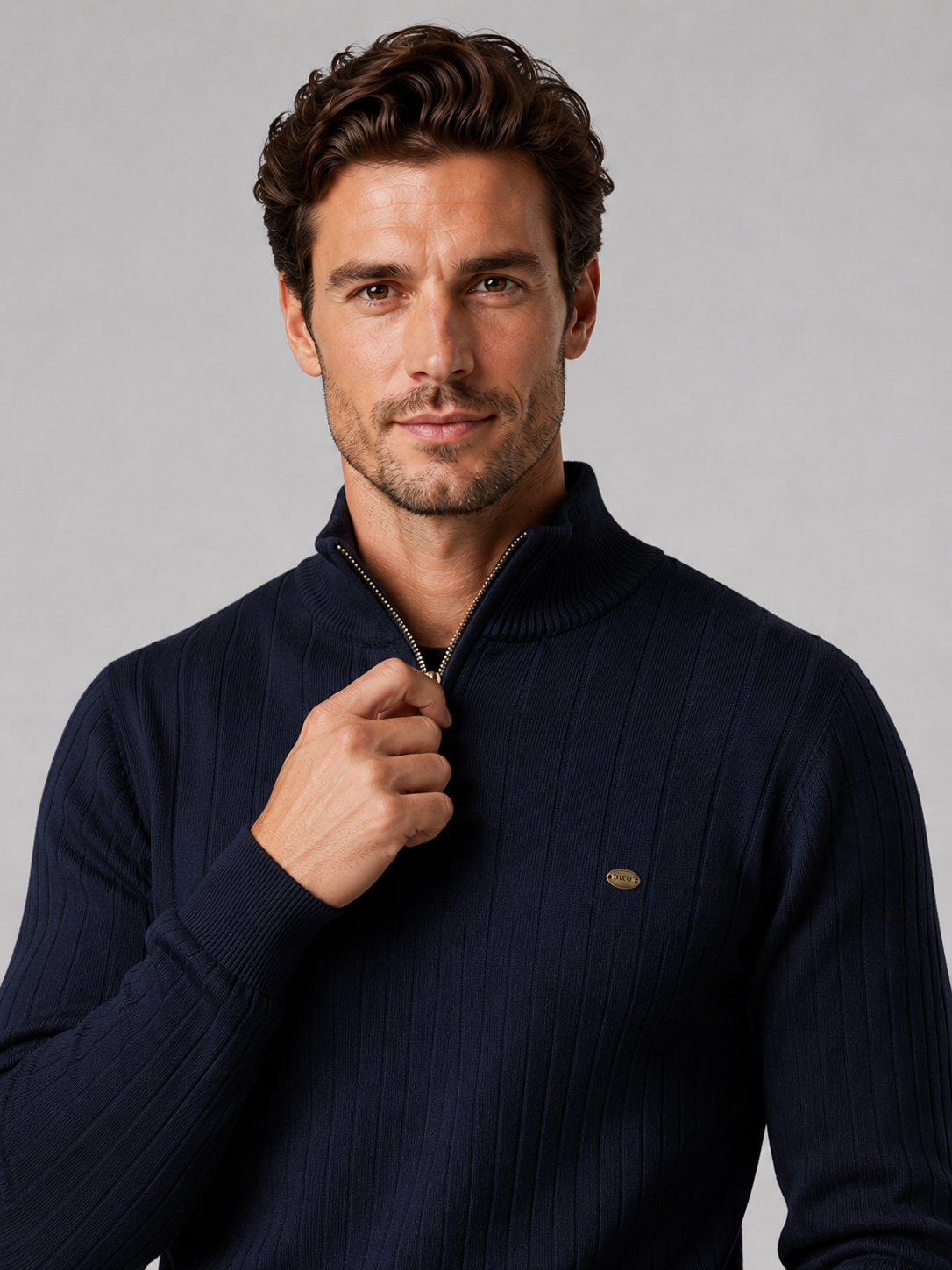 Close-up of a navy quarter zip pullover sweater showing the cotton knit texture, stand collar, zipper placket, cuffs, hem, and stitching details