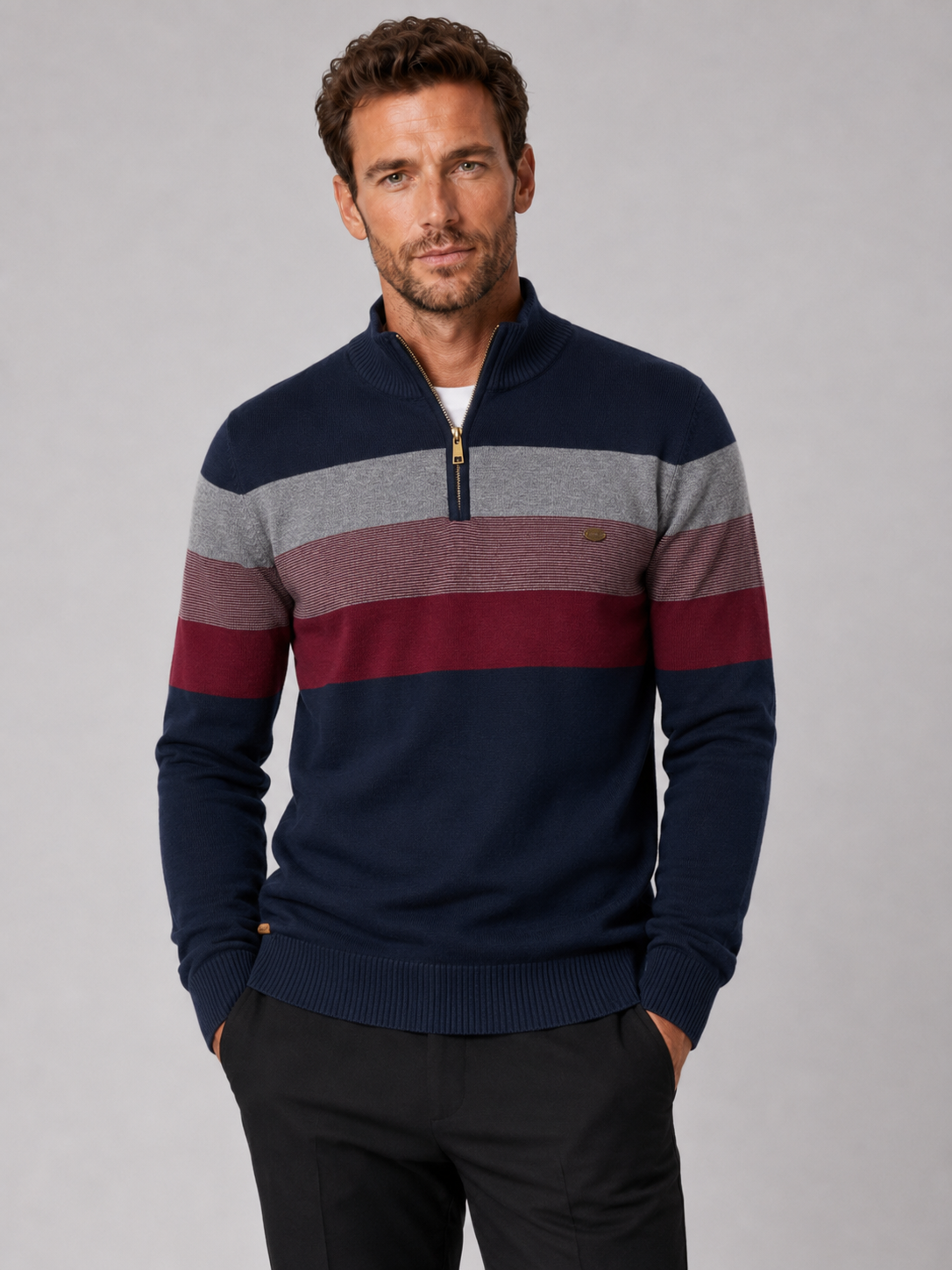 Front view of a man wearing a navy patchwork cotton quarter zip sweater with a mock neck and long sleeves