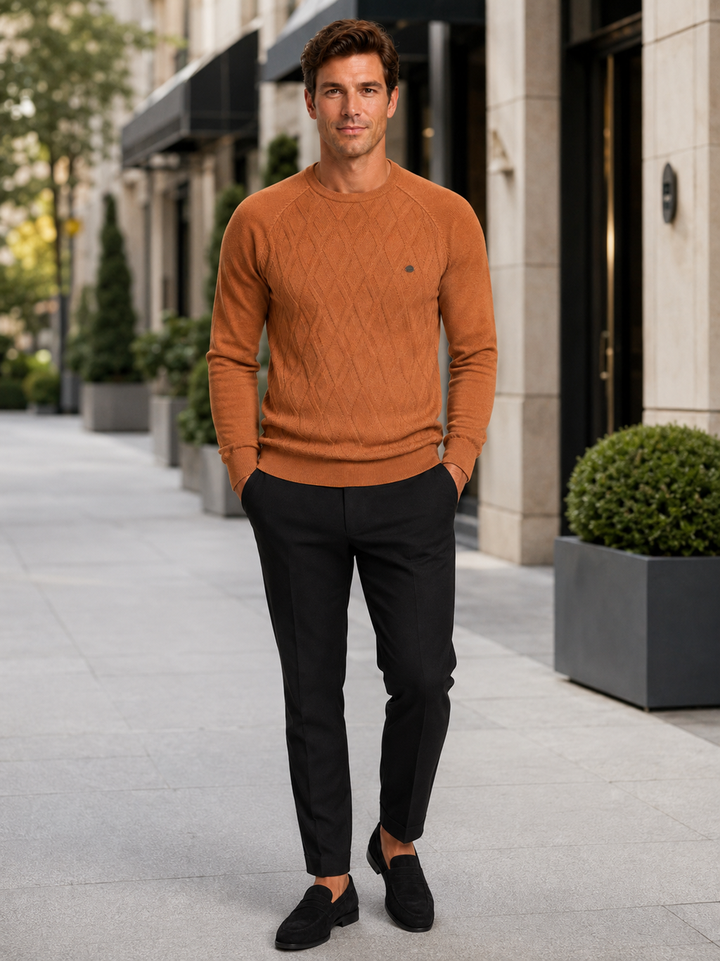 Man wearing an orange argyle crew neck sweater in a bold everyday winter outfit