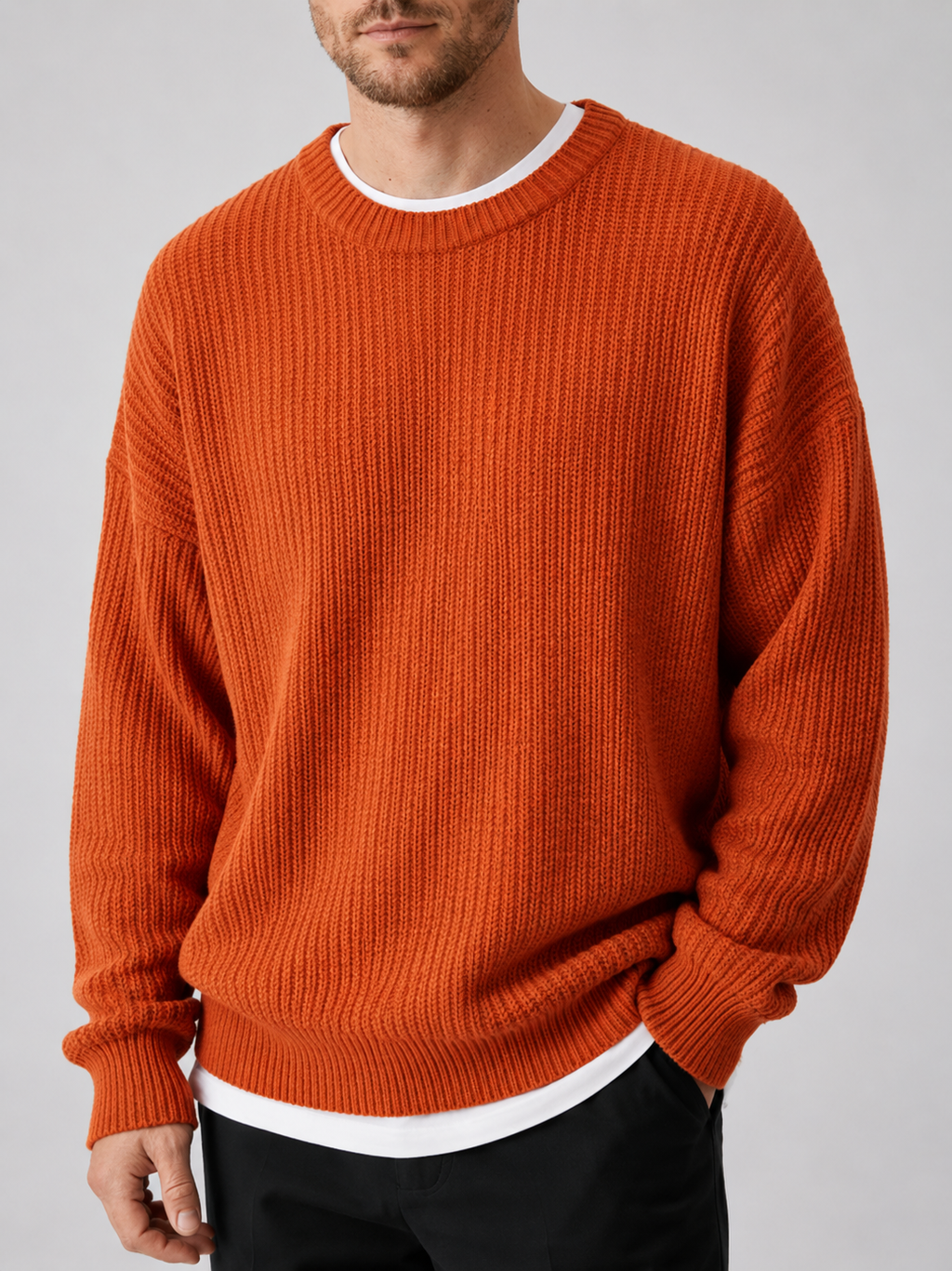 Close up of orange crewneck sweater showing soft knit texture and classic ribbed neckline detail