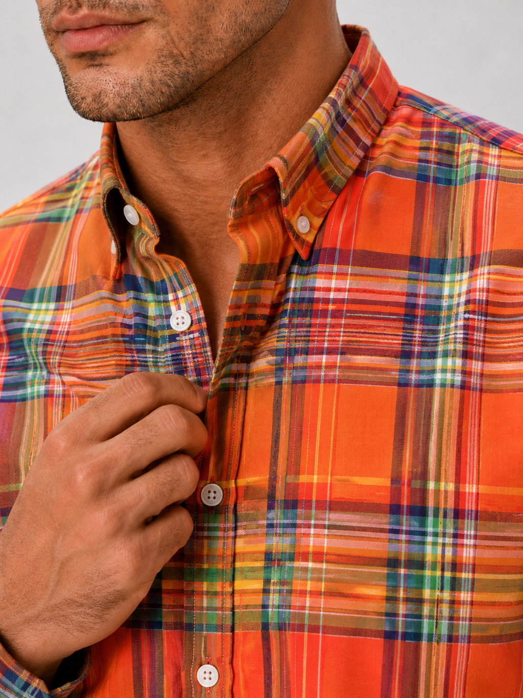 Close up of orange madras shirt showing soft cotton fabric and plaid striped pattern detail