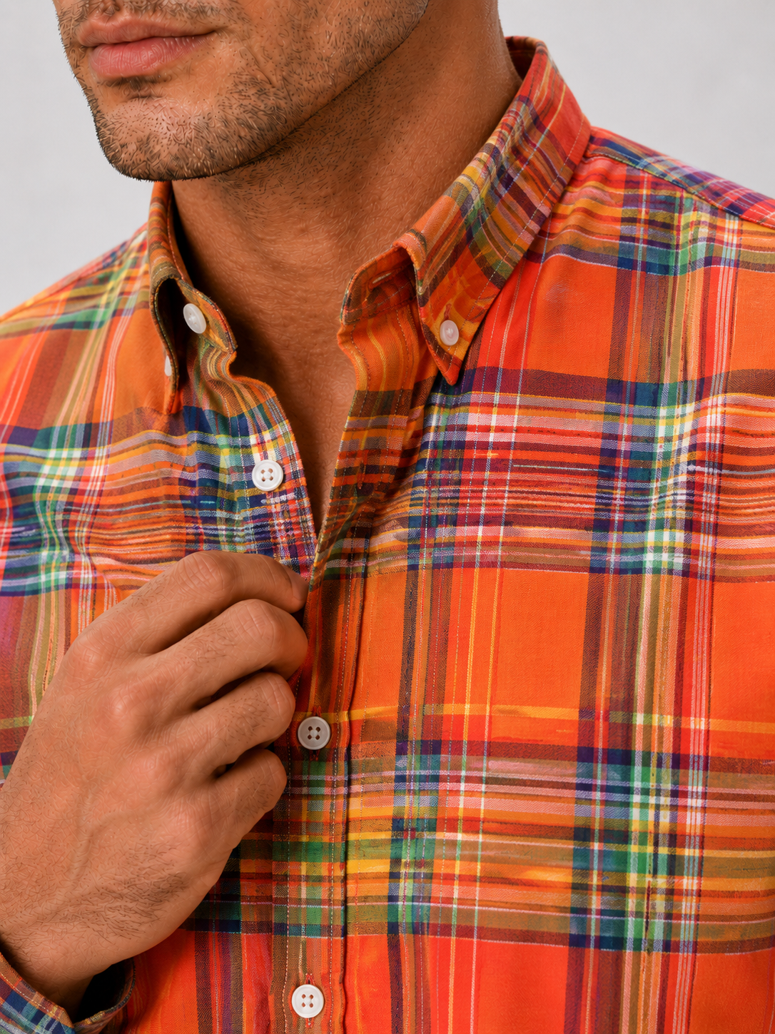 Close up of orange madras shirt showing soft cotton fabric and plaid striped pattern detail