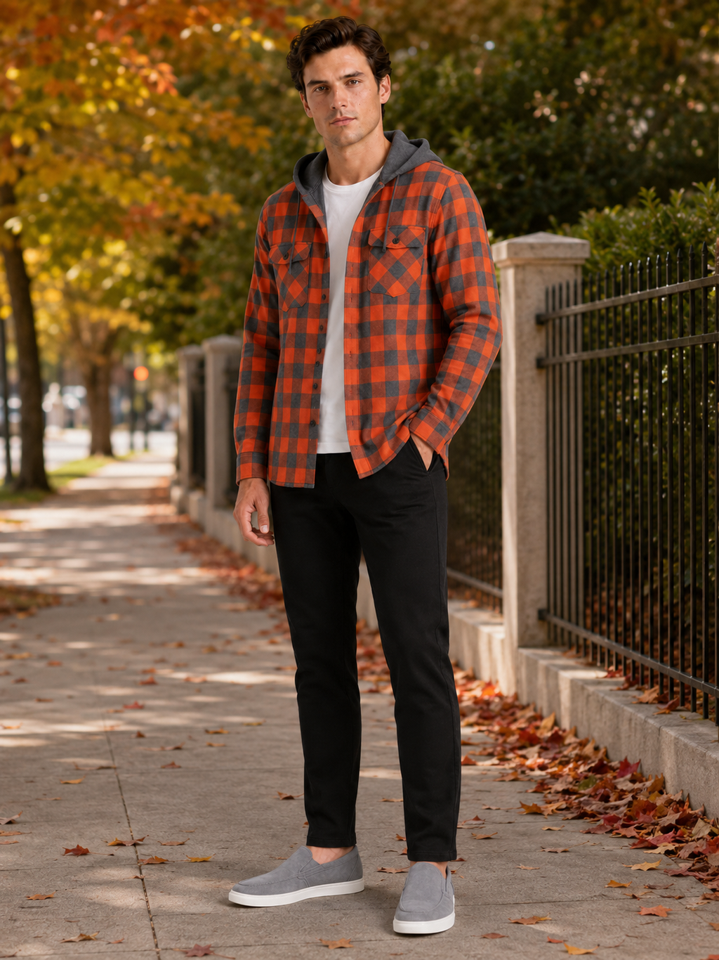 Man styling orange plaid hooded flannel jacket in a warm fall streetwear and outdoor lifestyle outfit