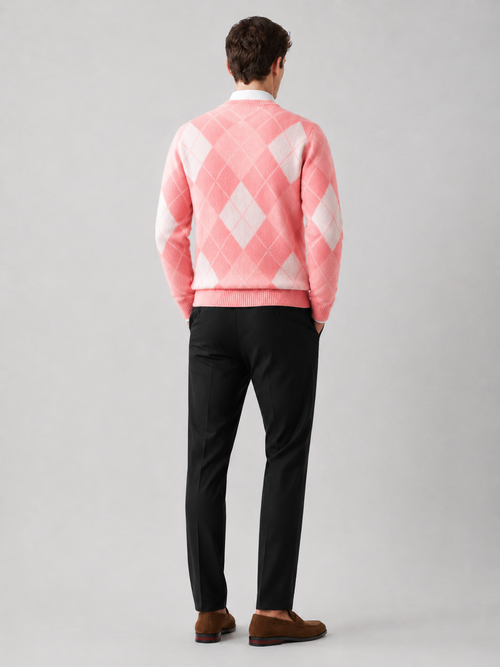 Back view of a man wearing a pink wool argyle sweater showing the crew neck, long sleeves, thick knit fabric, and comfortable fit