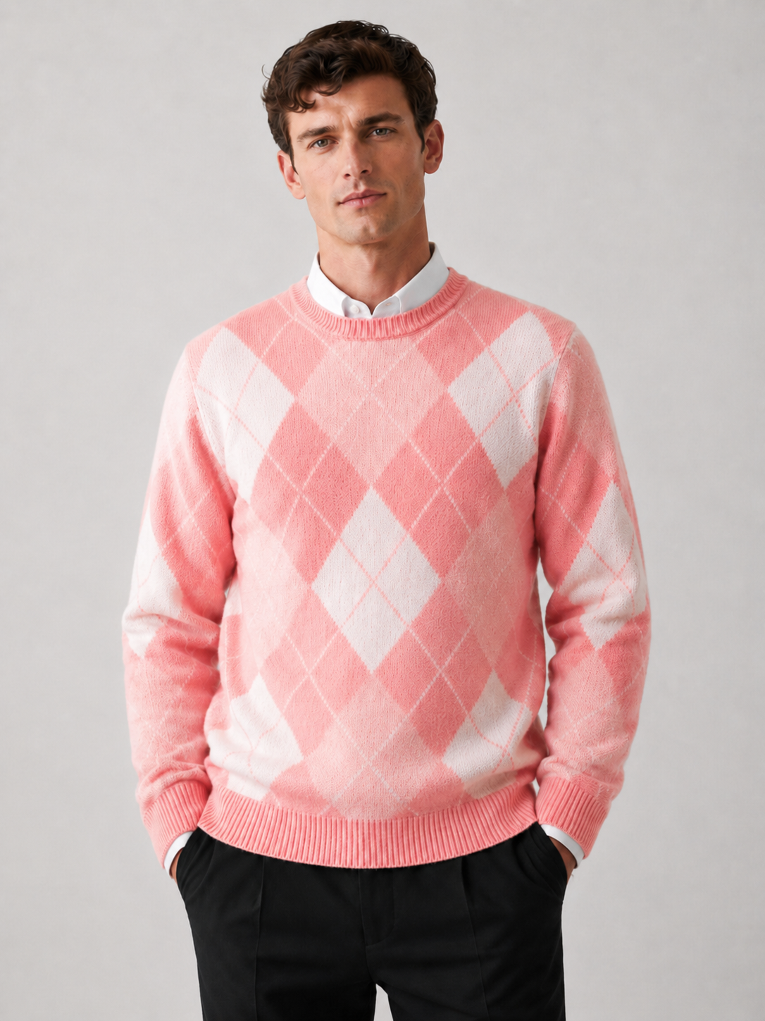 Front view of a man wearing a pink wool argyle sweater with a crew neck, long sleeves, and thick warm knit construction
