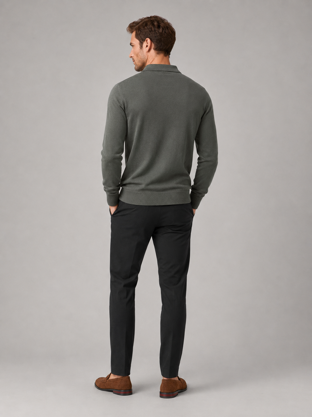 Back view of a man wearing a green quarter zip polo shirt showing the slim fit, long sleeves, and textured fabric construction