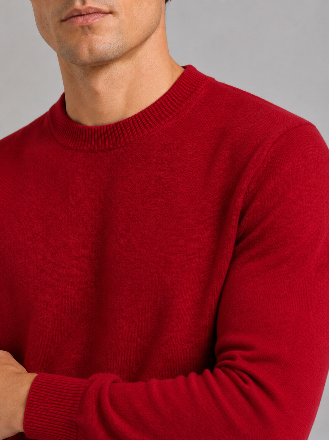 Close up of red knit sweater showing soft textured fabric and classic crew neck detail