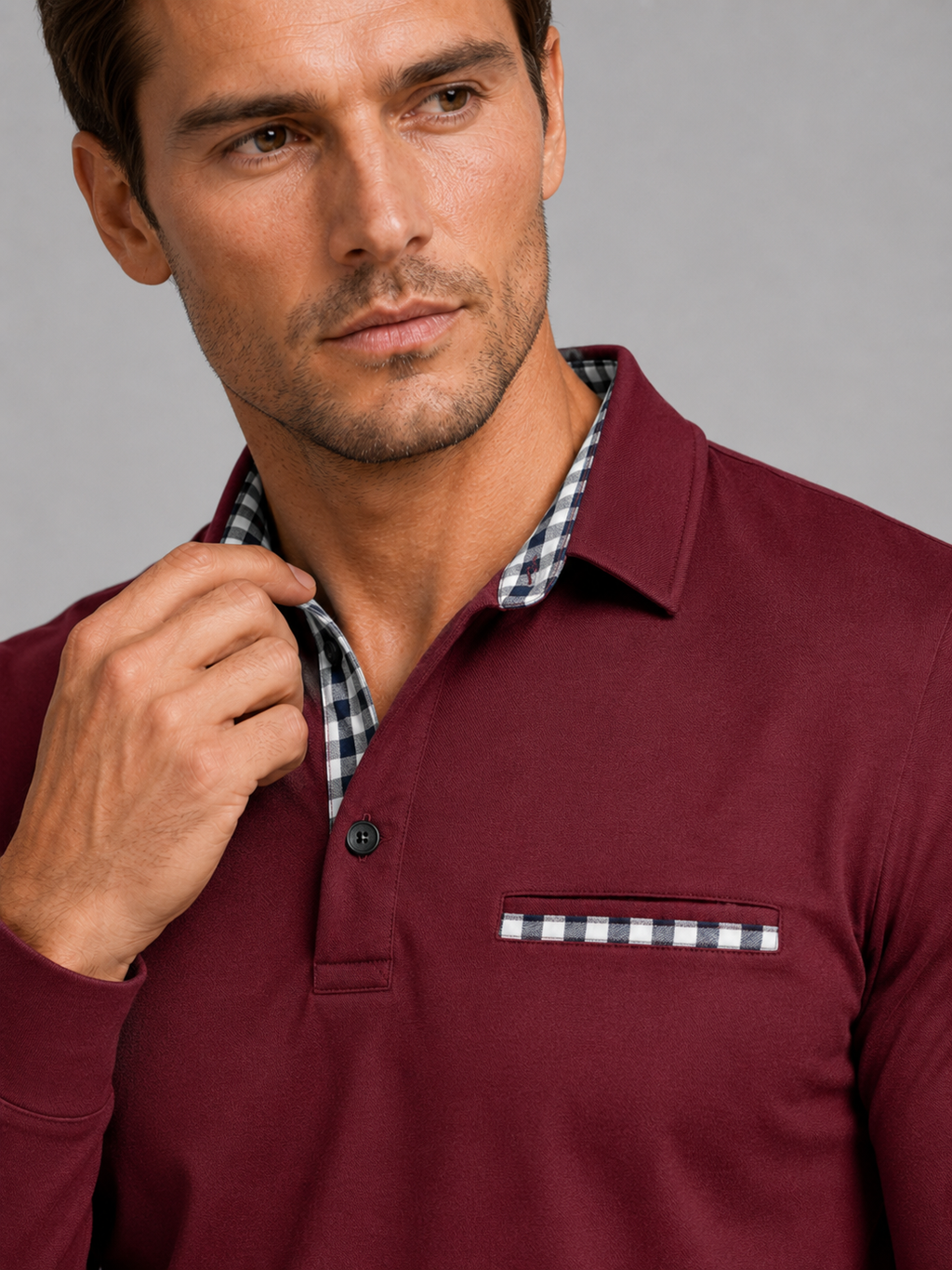 Close up of wine polo shirt showing plaid panel detail, soft fabric, and classic collar