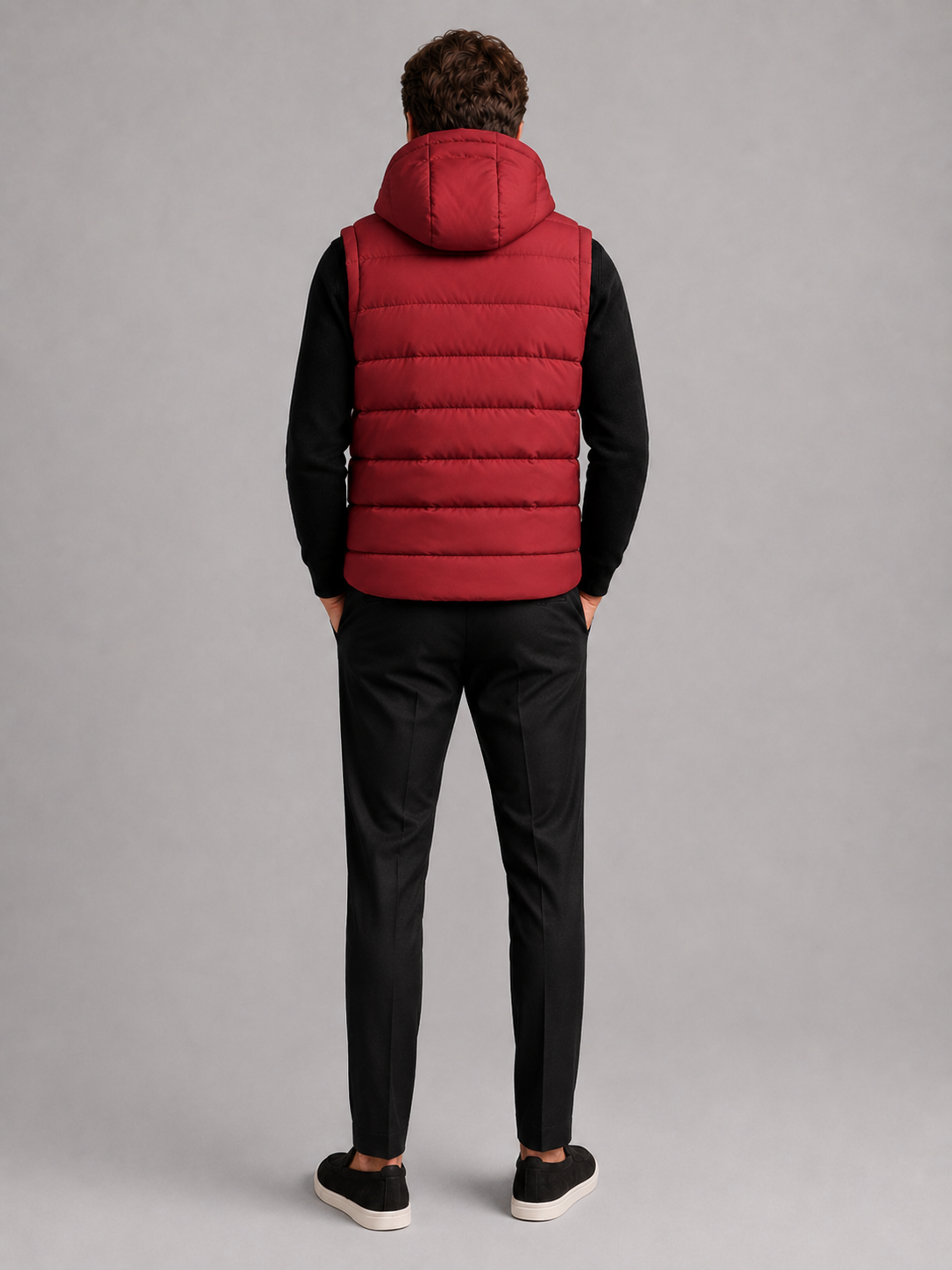 Back view of a man wearing a red hooded puffer vest showing the attached hood, padded construction, sleeveless cut, and comfortable fit
