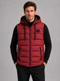 Front view of a man wearing a red hooded puffer vest with cotton padding, thick insulation, sleeveless design, and full zip front