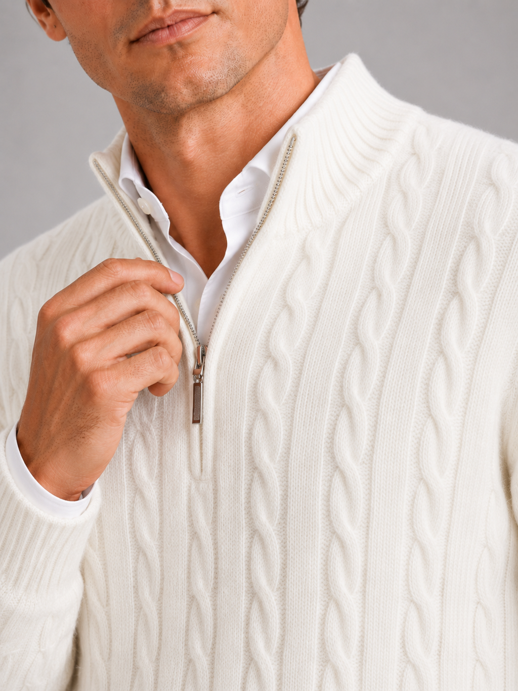 Close up of white cashmere sweater showing soft cable knit texture and quarter zip detail