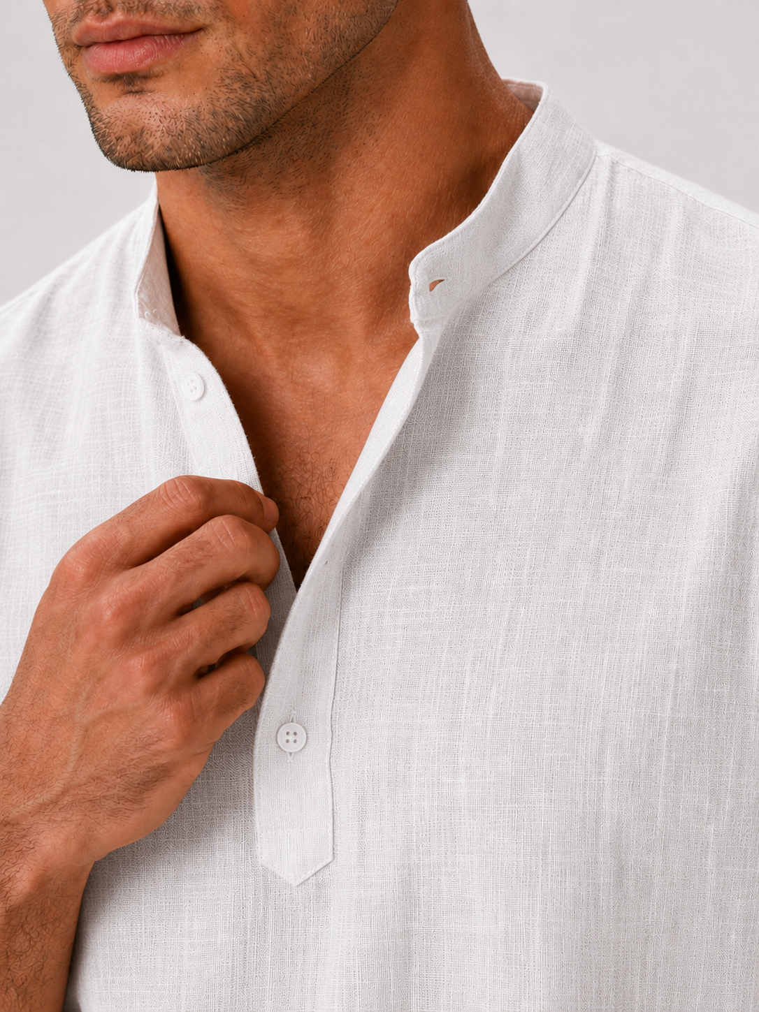 Close up of white band collar shirt showing soft breathable fabric and button up detail