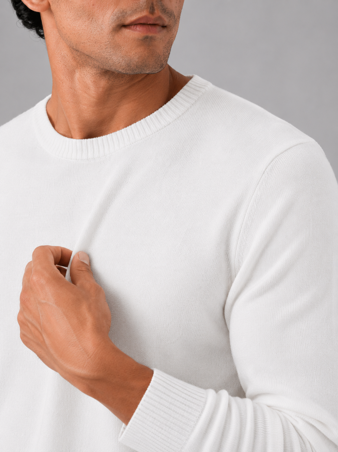 Close up of white knit sweater showing soft lightweight fabric and clean crew neck detail