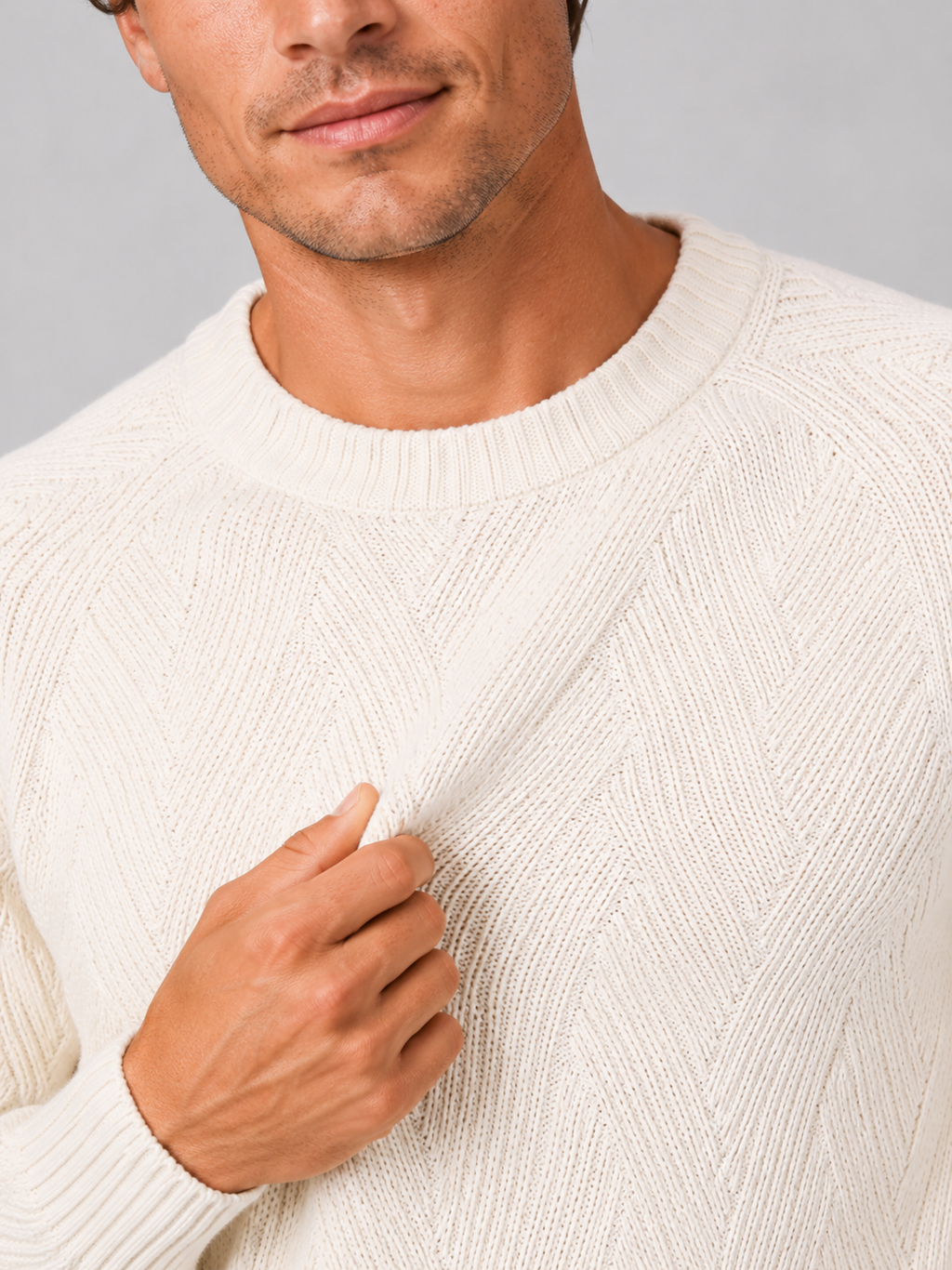 Close up of white knit sweater showing soft textured fabric and classic crew neck detail