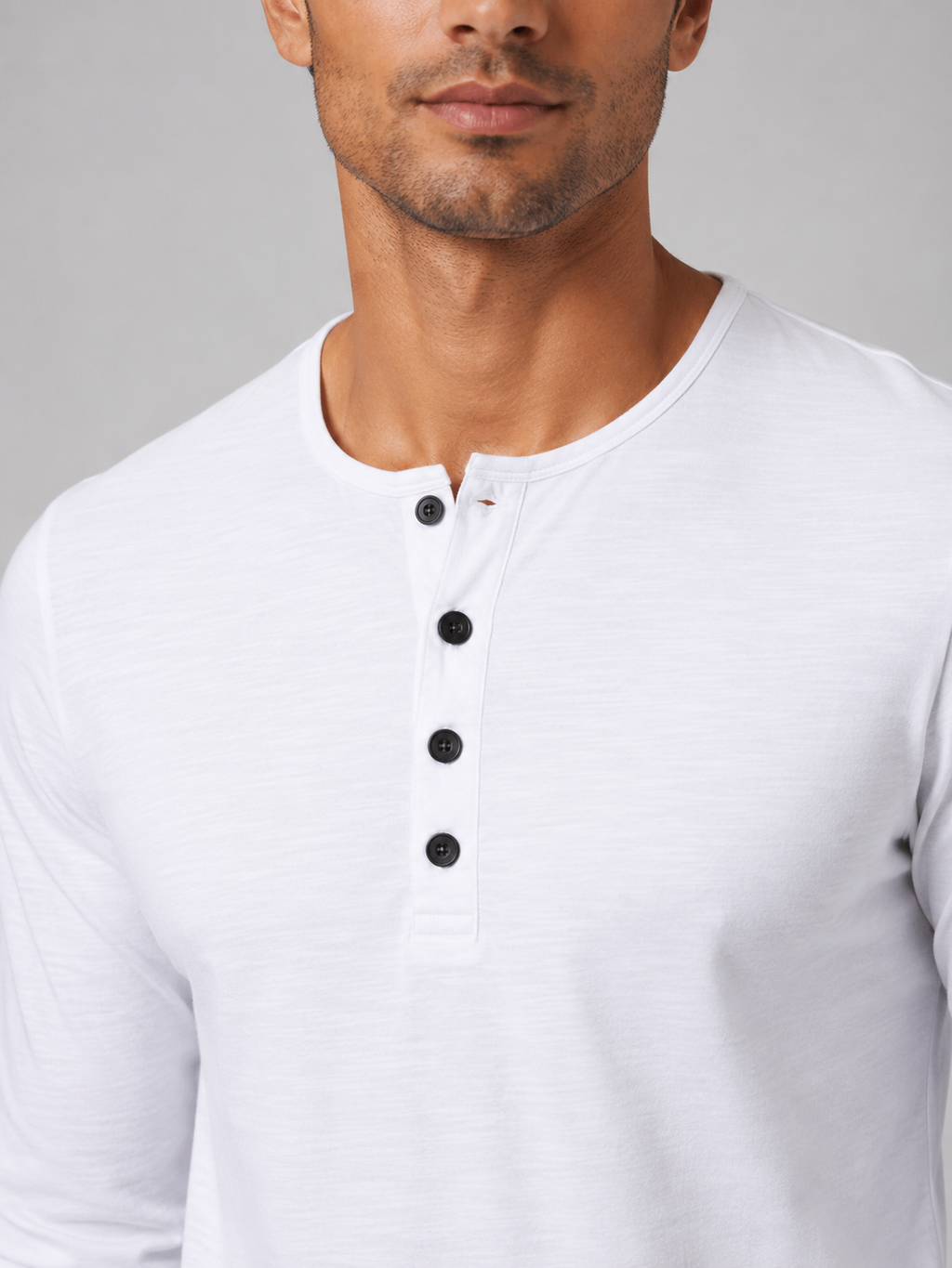 Close up of white henley shirt fabric showing soft smooth breathable texture and button detail