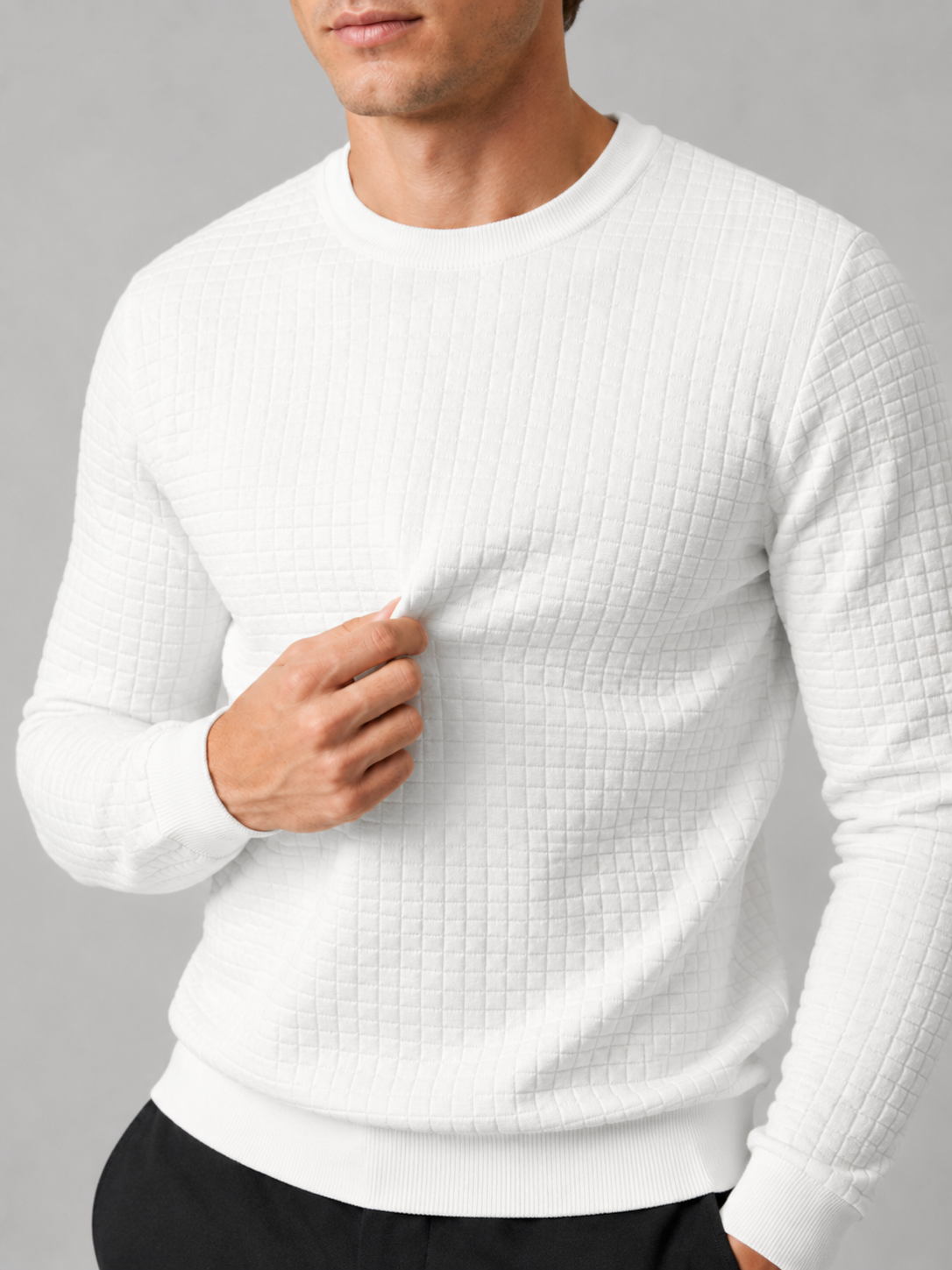 Close up of white jacquard sweater showing textured knit pattern and classic crew neck detail
