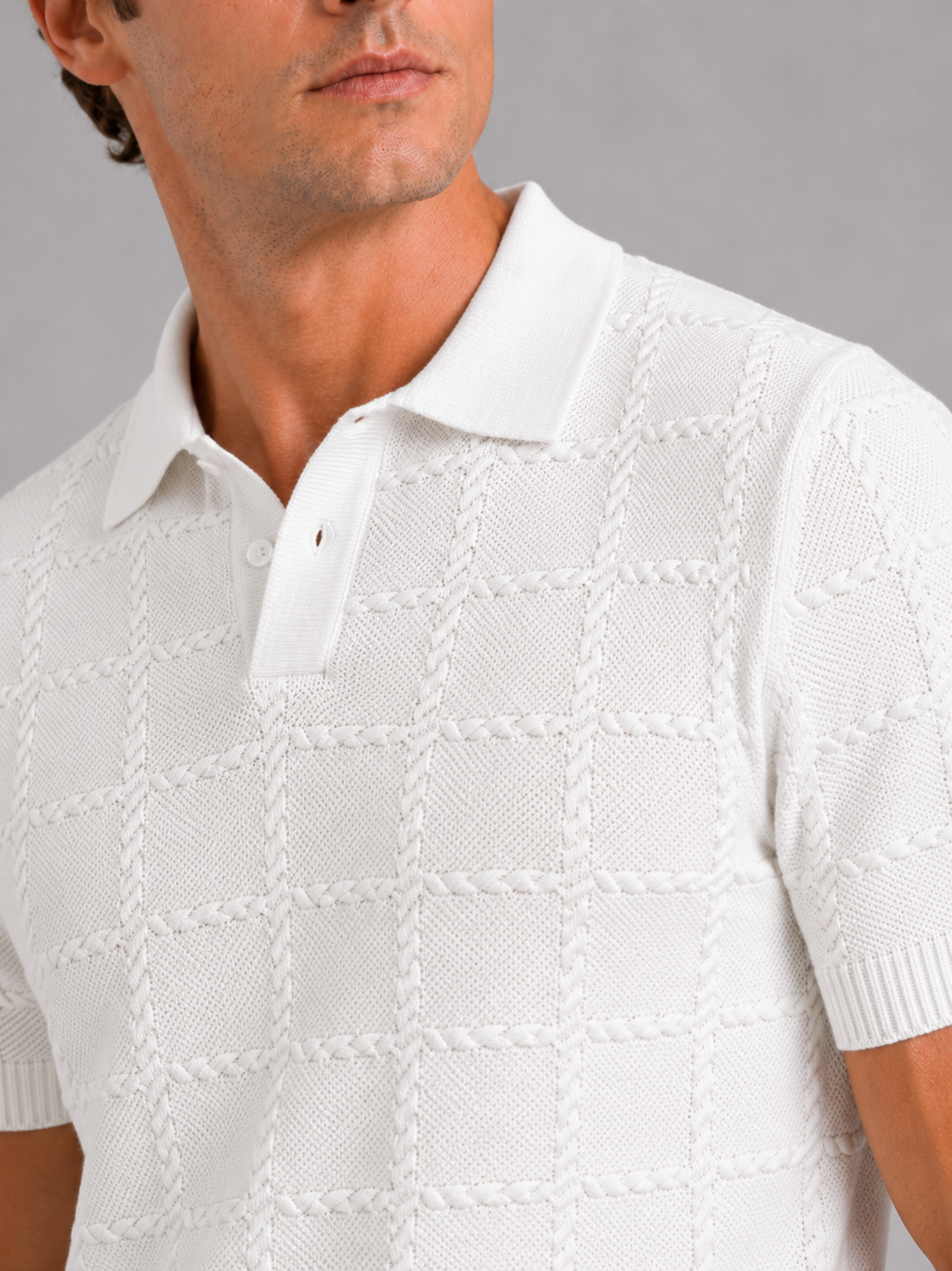 Close up of white jacquard polo shirt showing textured fabric and refined lapel collar detail