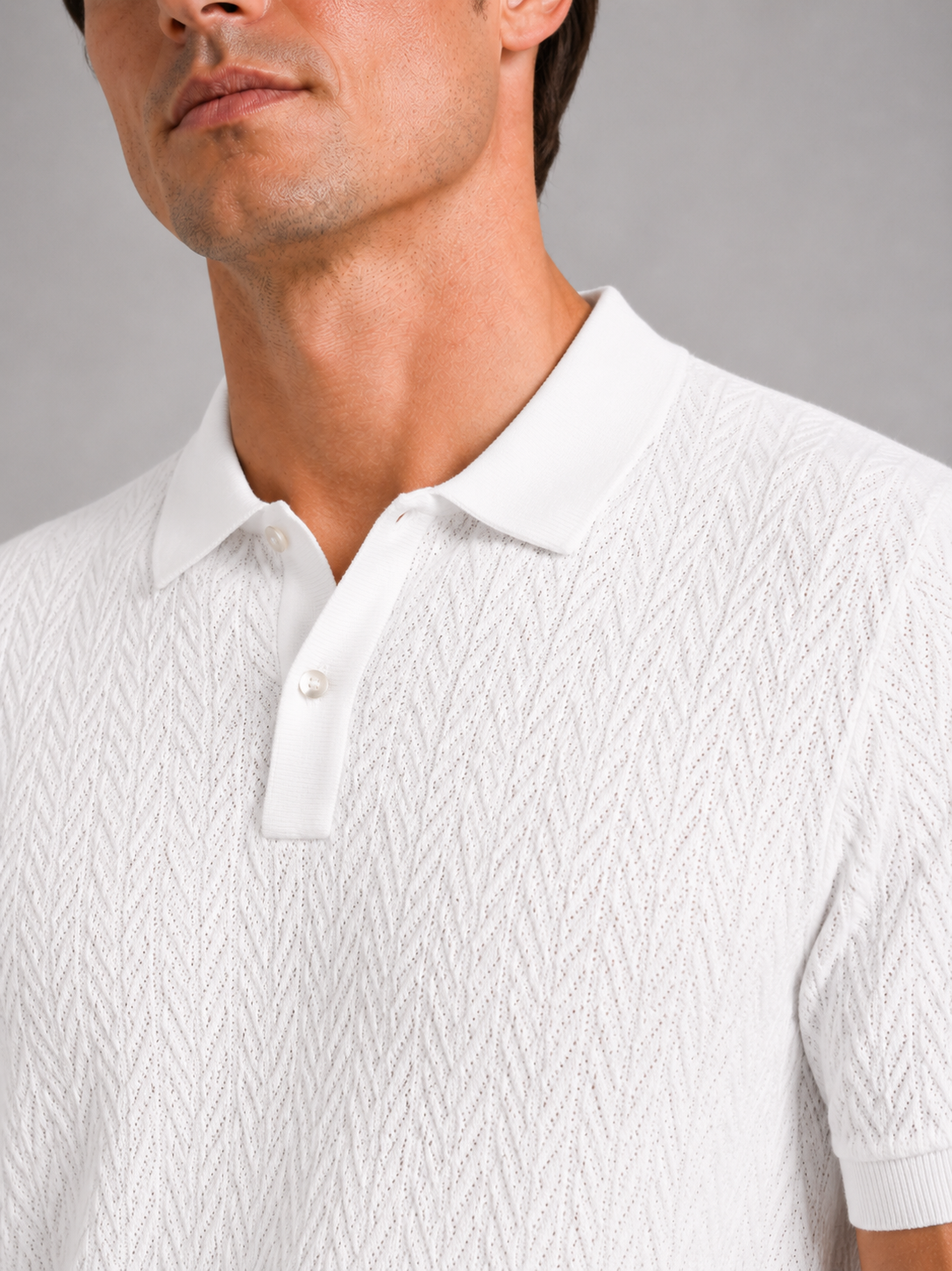 Close up of white knit polo shirt showing soft breathable fabric and refined collar detail