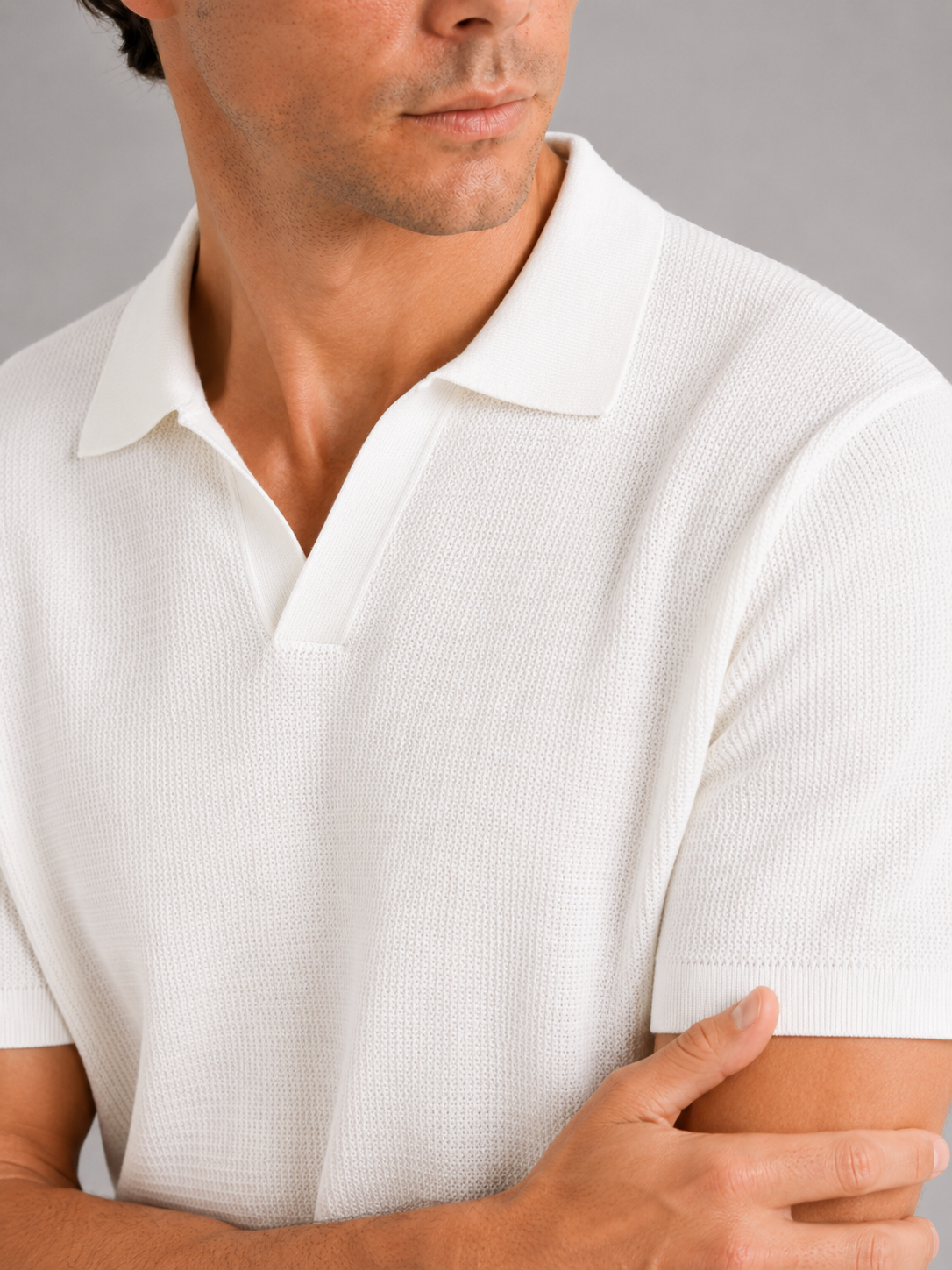 Close up of white knit polo t shirt showing soft breathable fabric and refined collar detail