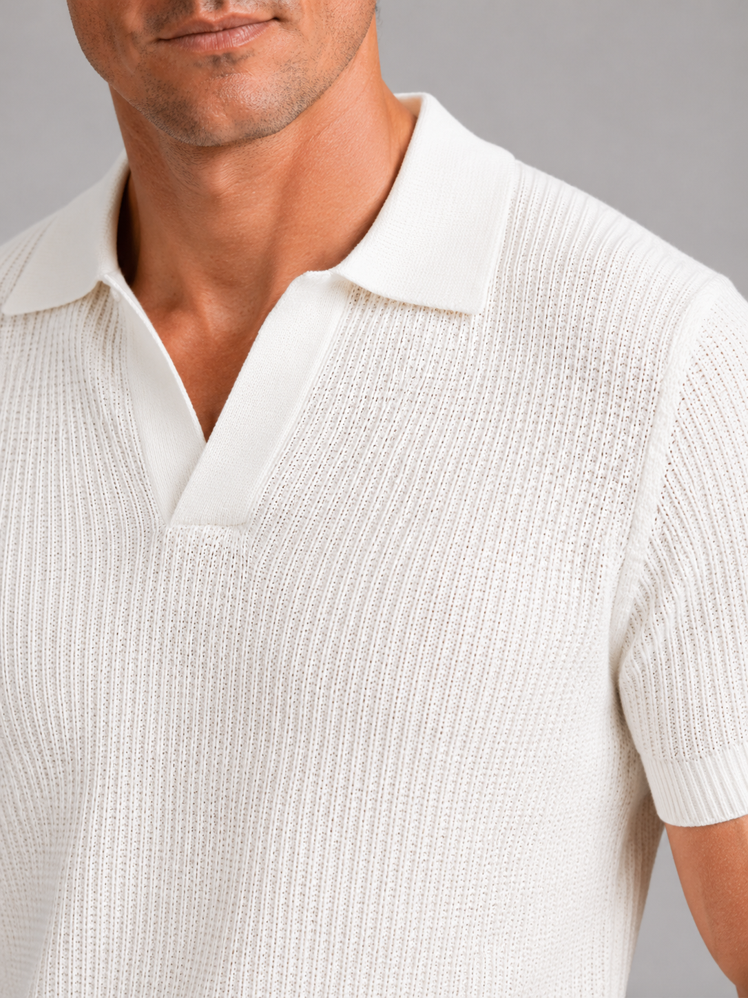 Close up of white knit polo showing soft breathable fabric and refined collar detail