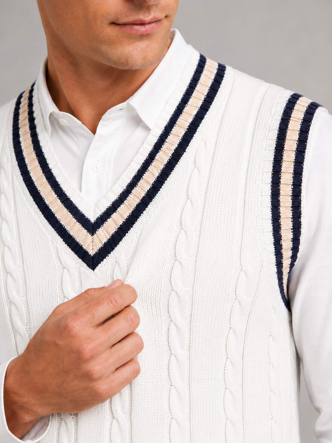 Close up of white striped sweater vest showing thick knit texture and classic v neck detail