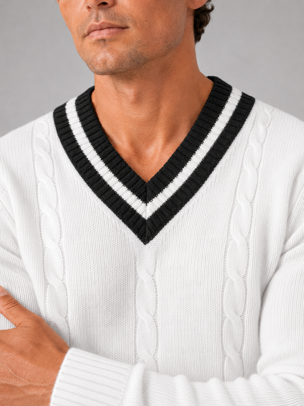 Close up of white knit sweater showing soft warm fabric and refined v neck detail