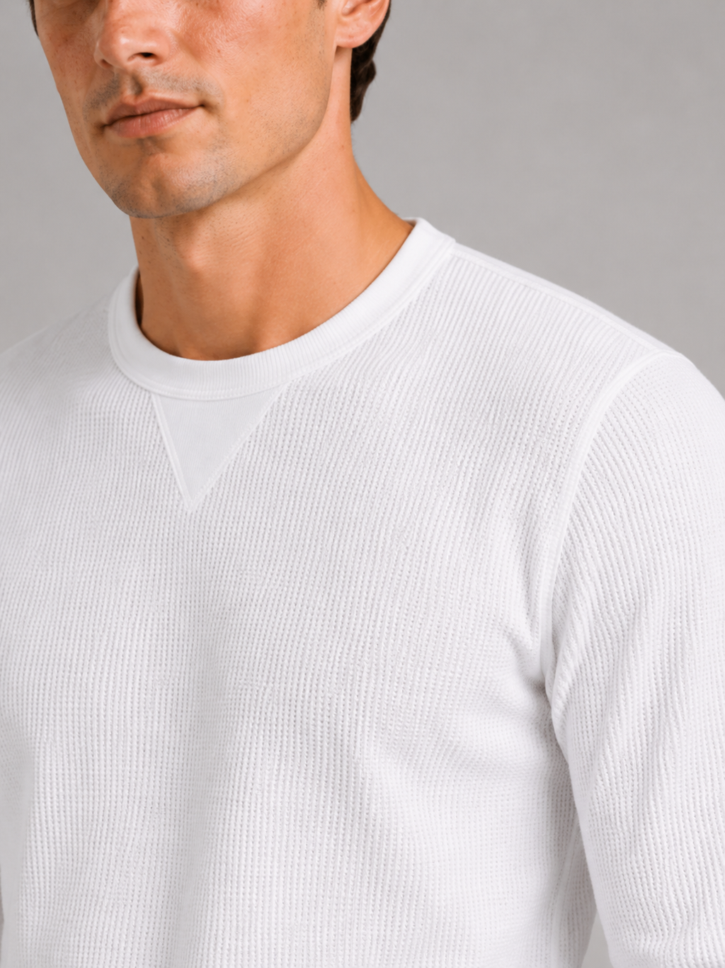 Close up of white waffle knit shirt showing textured thermal fabric and soft knit detail