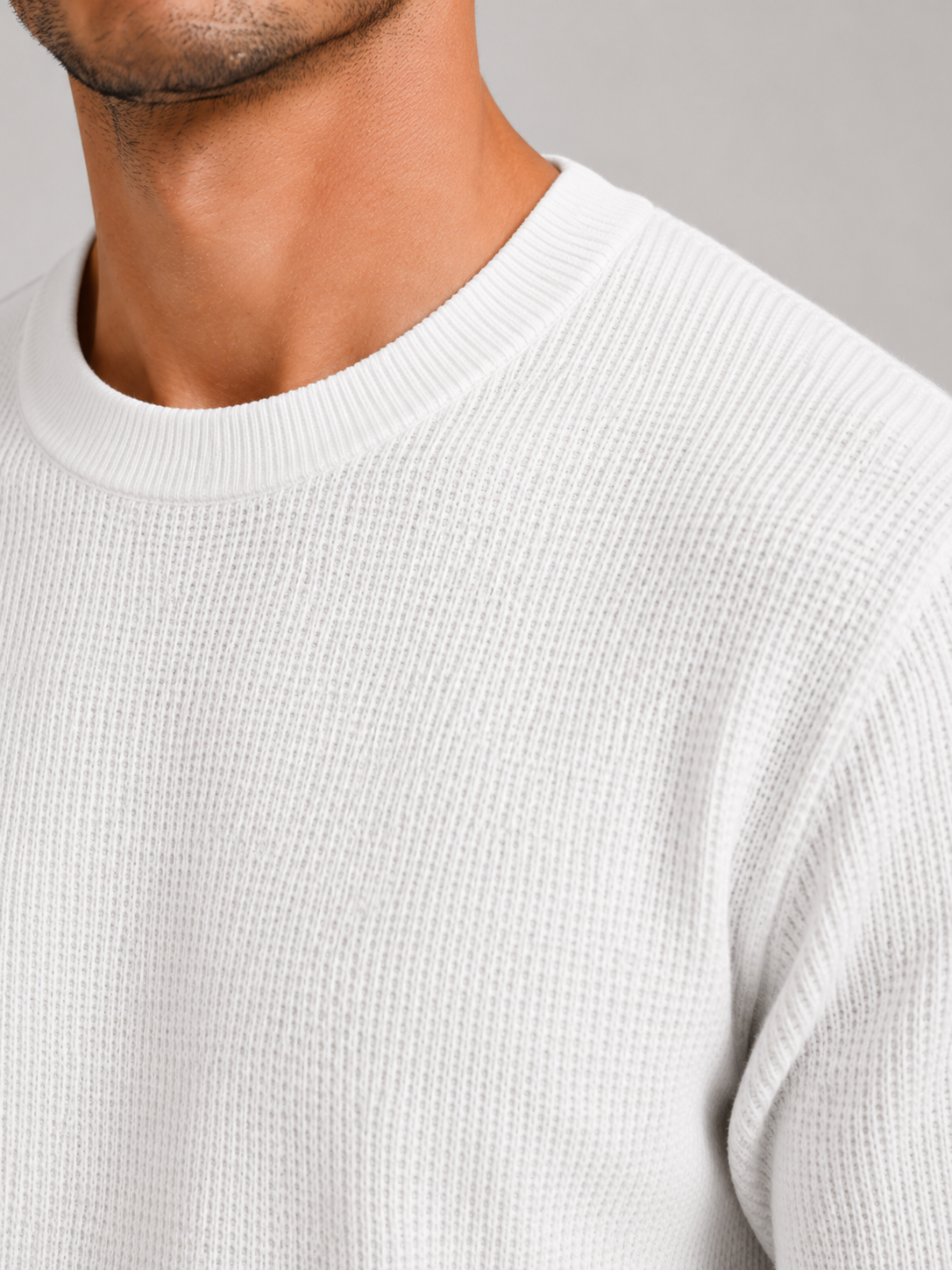 Close up of white waffle knit fabric showing soft breathable textured weave and lightweight finish