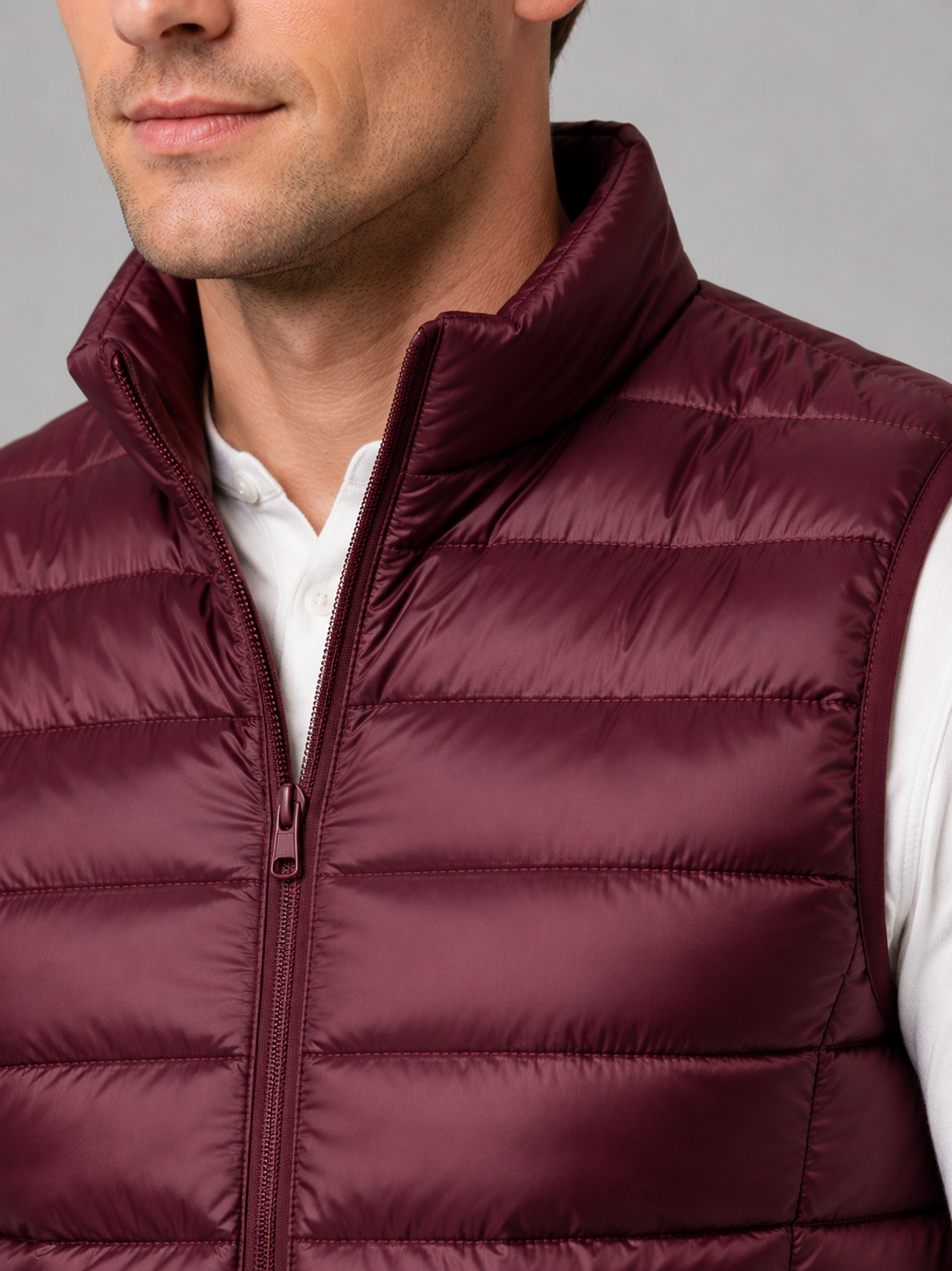 Close up of wine down puffer vest showing lightweight quilted insulation, stand collar, and zip front detail
