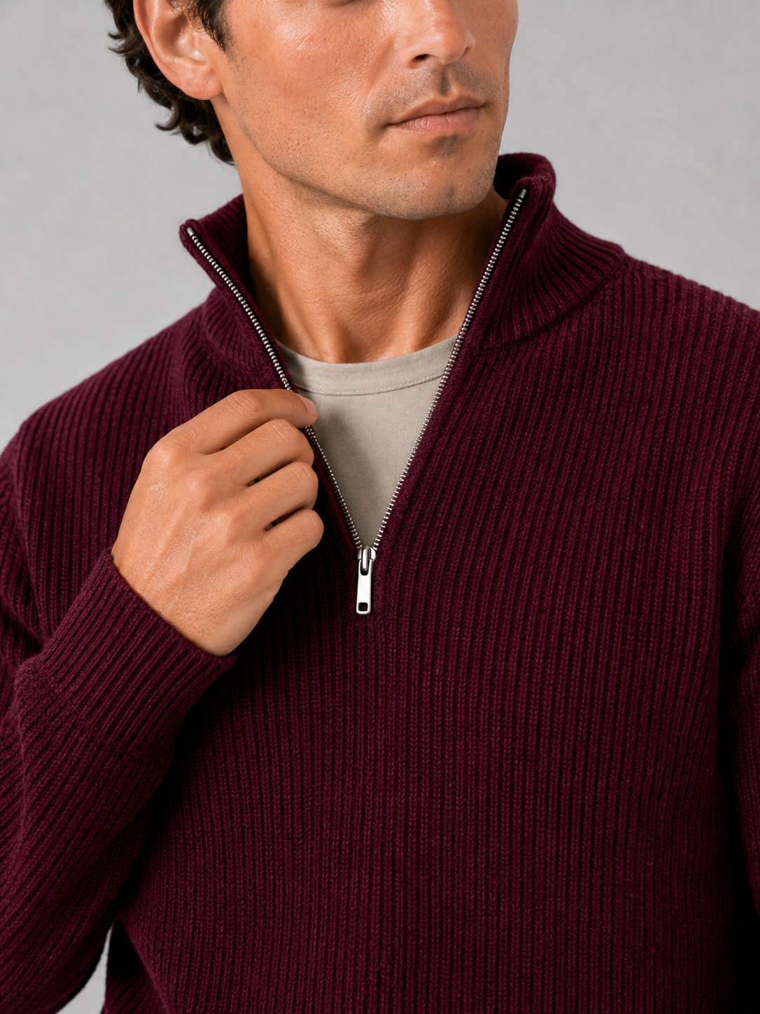 Close up of wine half zip sweater showing thick knit texture and refined zipper detail