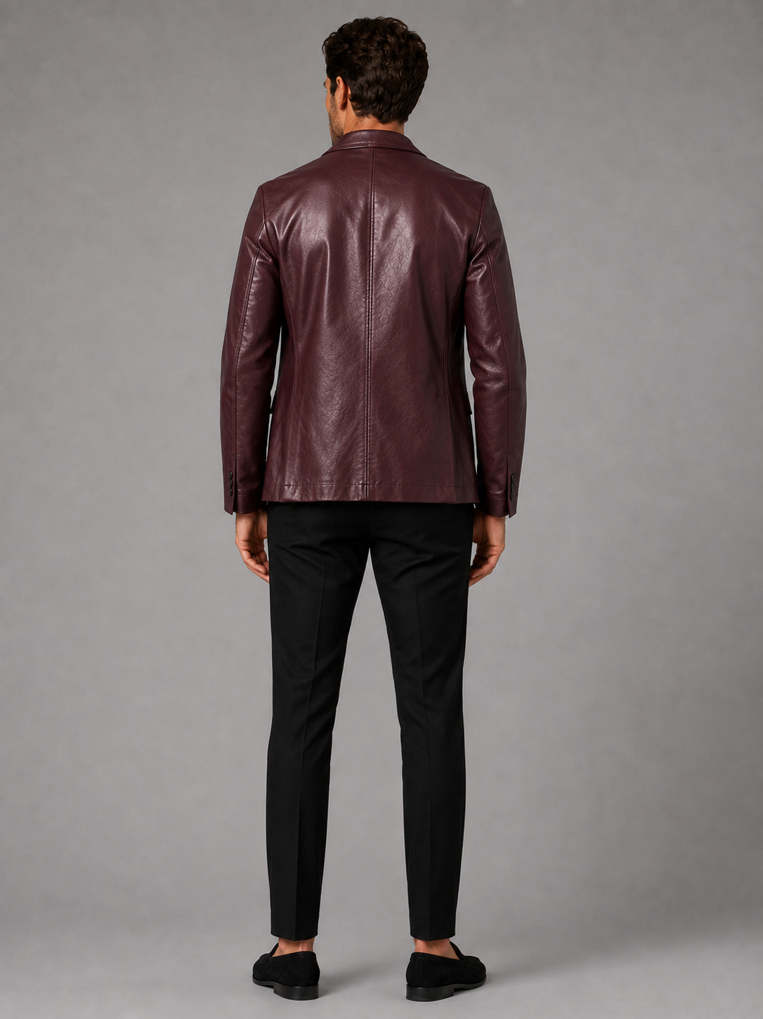 Back view of a man wearing a wine red leather blazer jacket showing the tailored slim fit, smooth leather finish, and structured silhouette