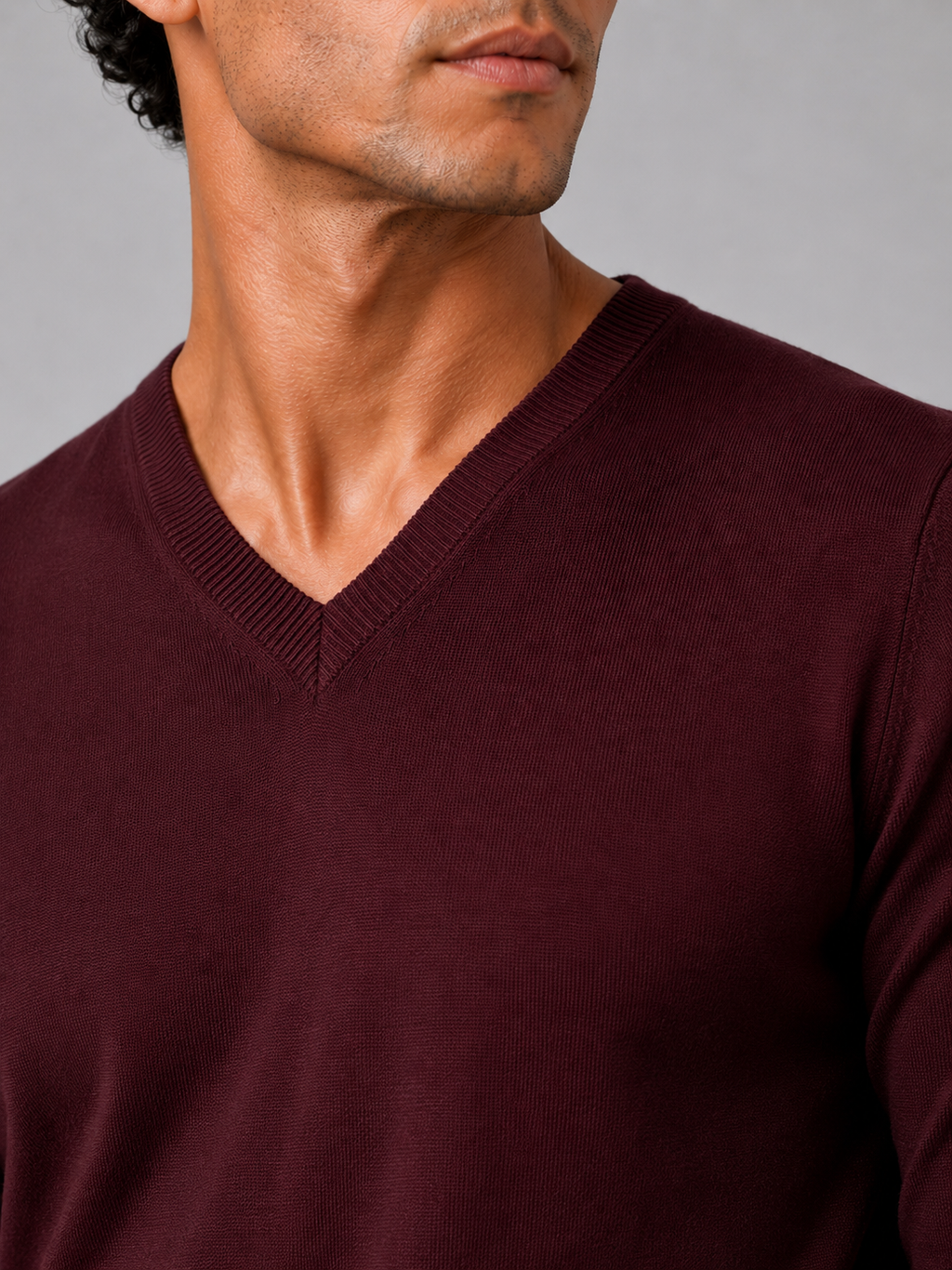 Close up of wine knit sweater showing soft lightweight fabric and refined v neck detail